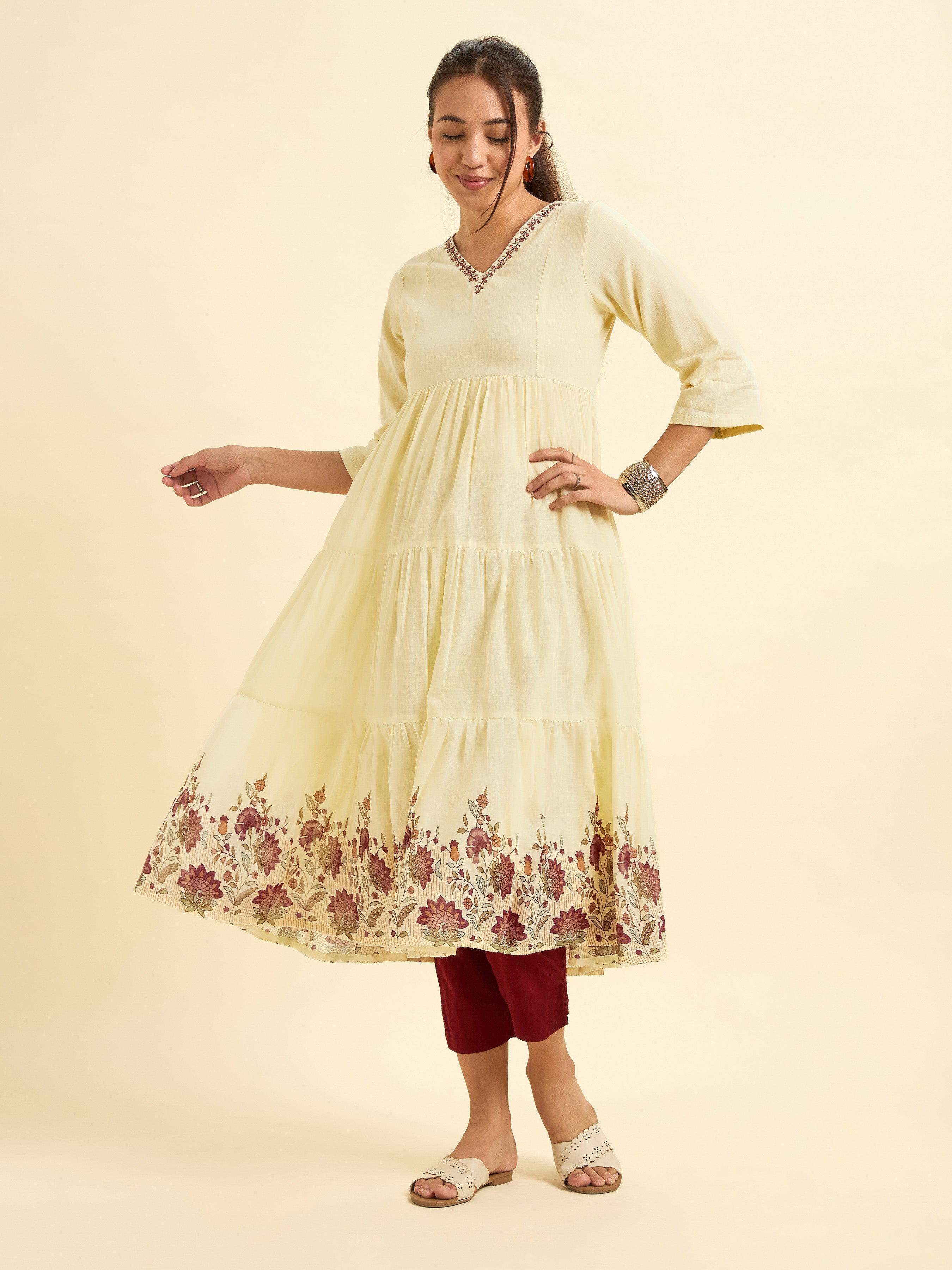 Women Wearing Pale Yellow Pure Cotton Tiered Kurti With Print And Embroidery