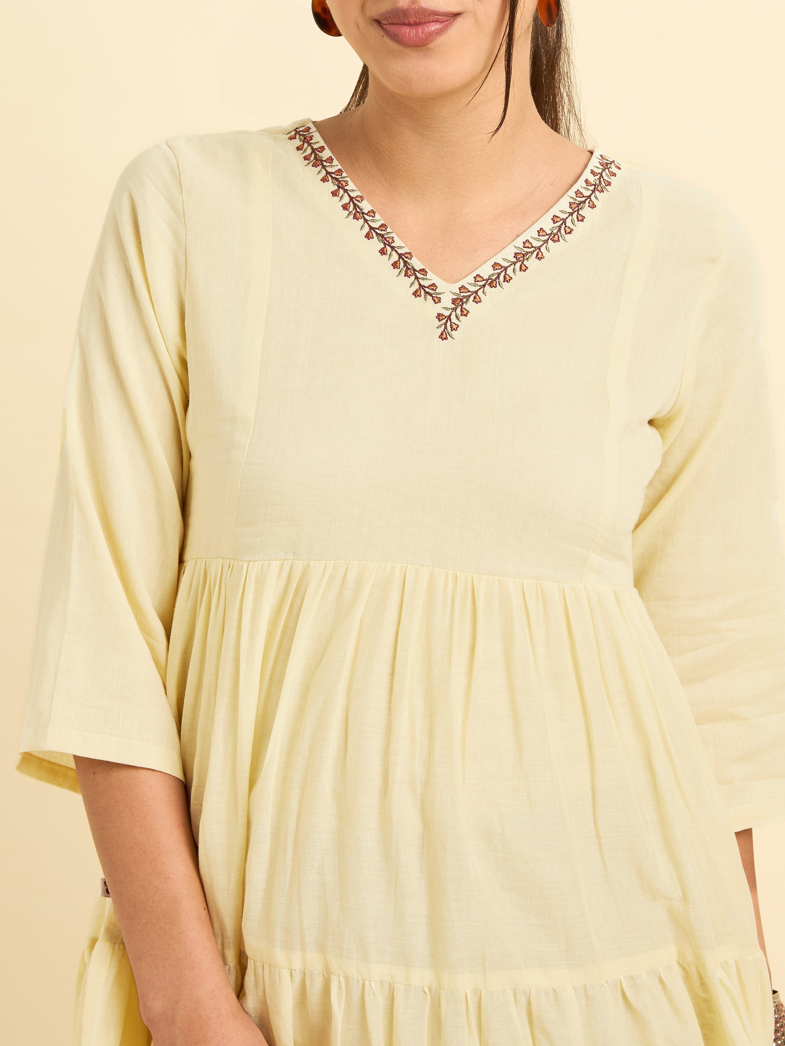 Women Wearing Pale Yellow Pure Cotton Tiered Kurti With Print And Embroidery