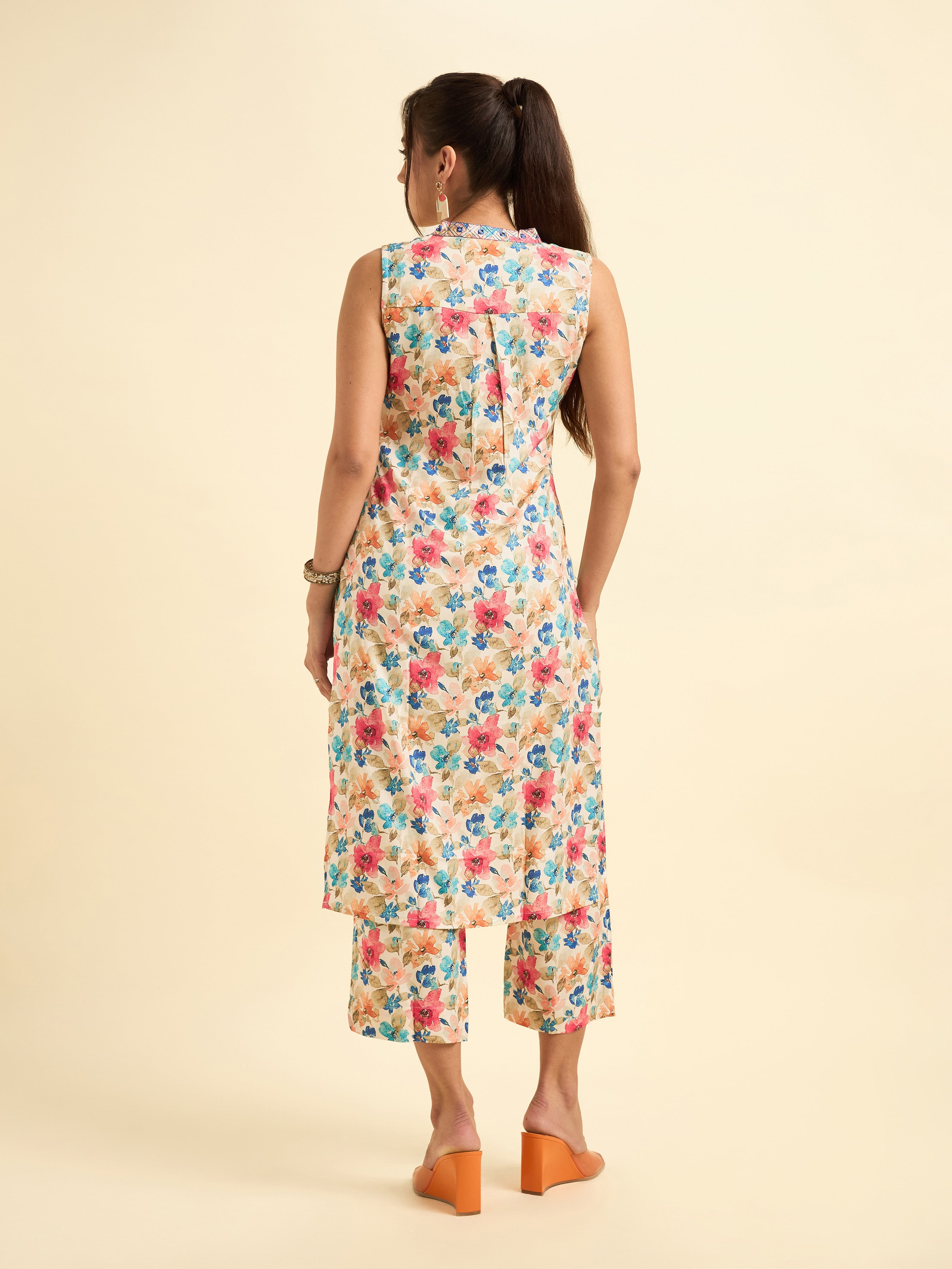 Women Wearing Ivory Multi Colour Cotton Flax Printed Sleeveless Kurti Set With Mirror Work Embroidery