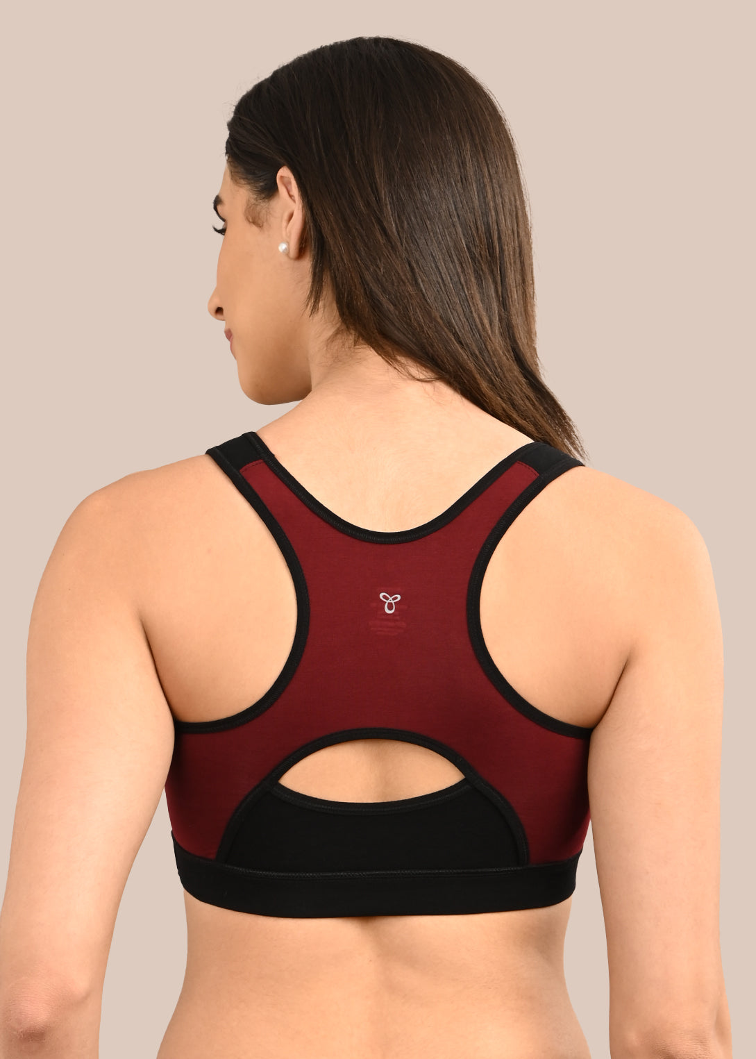 Woman wearing a bra against a neutral background