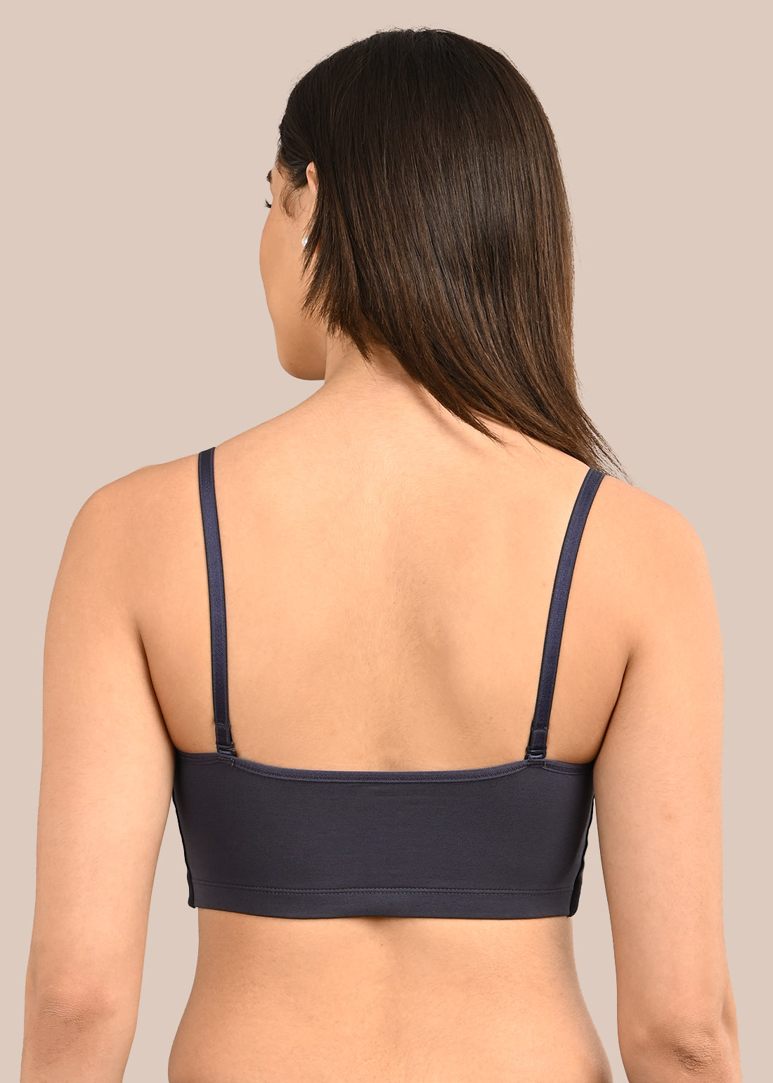 Woman wearing a bra against a neutral background