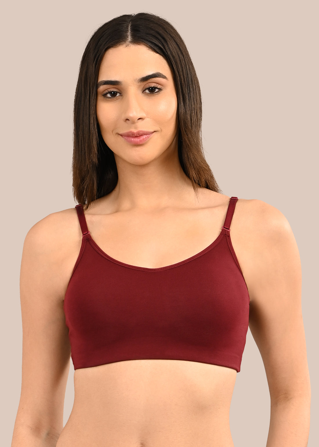 Woman wearing a bra against a neutral background