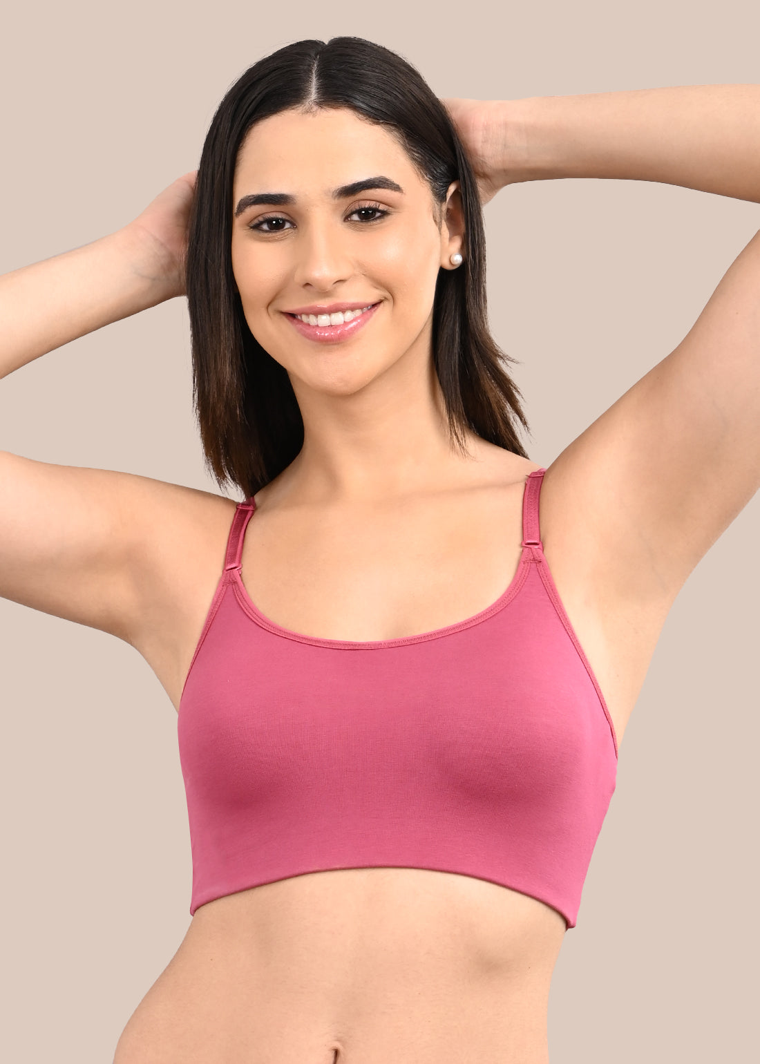 Woman wearing a bra against a neutral background
