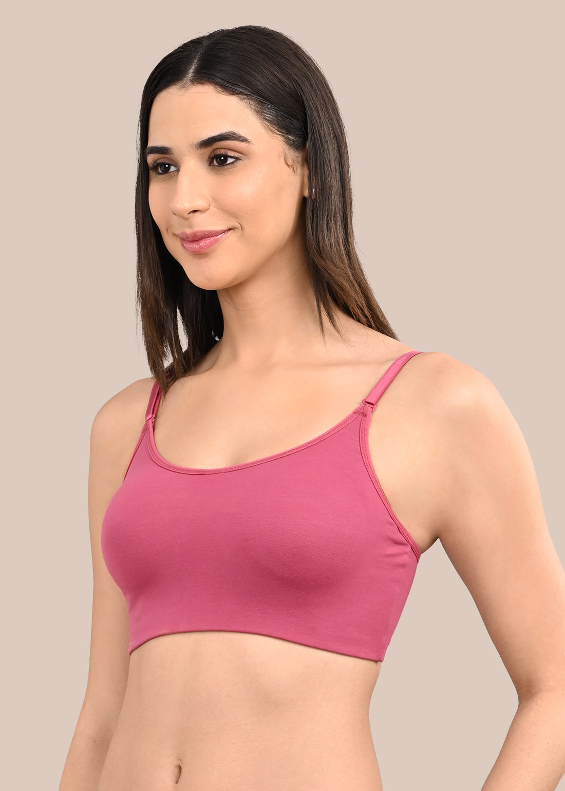 Woman wearing a bra against a neutral background