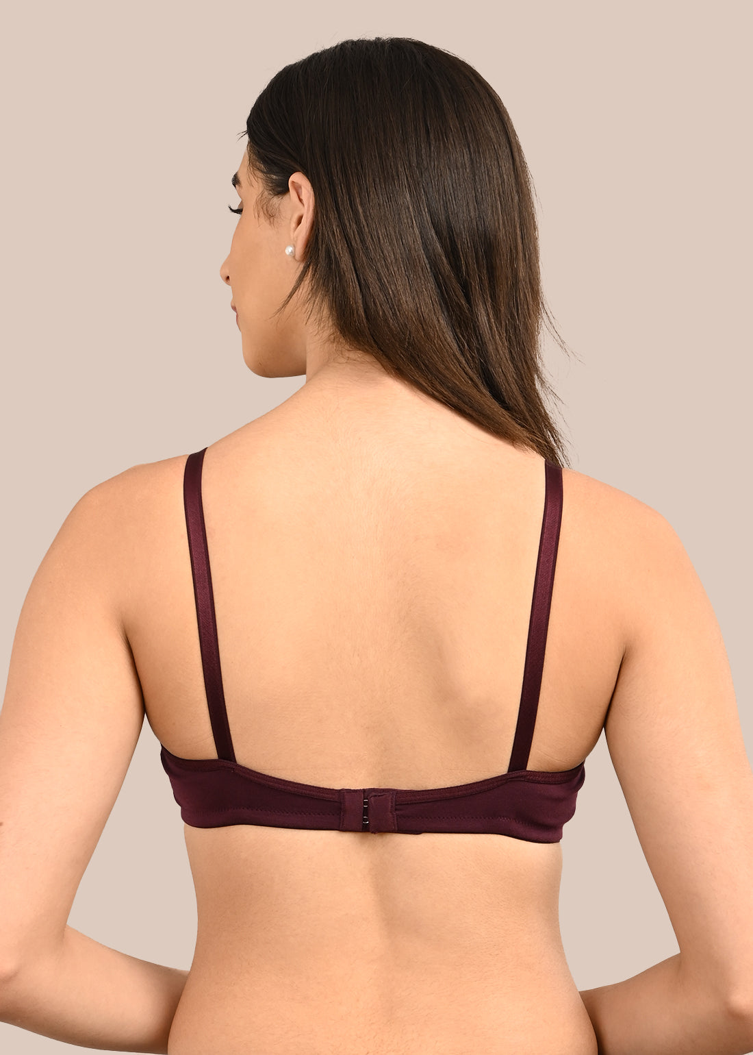 Woman wearing a bra against a neutral background