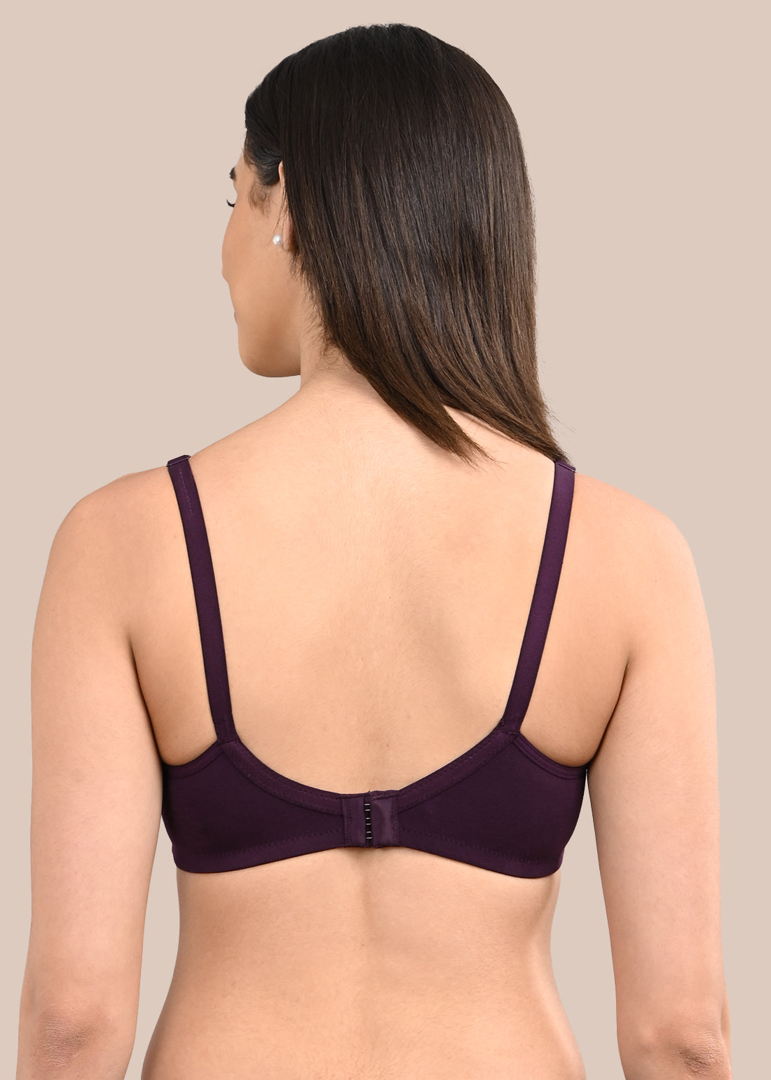 Woman wearing a bra against a neutral background
