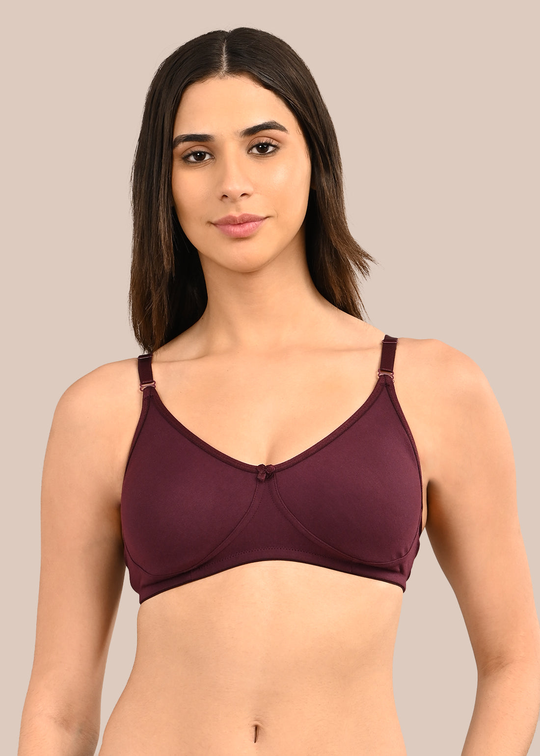 Woman wearing a bra against a neutral background