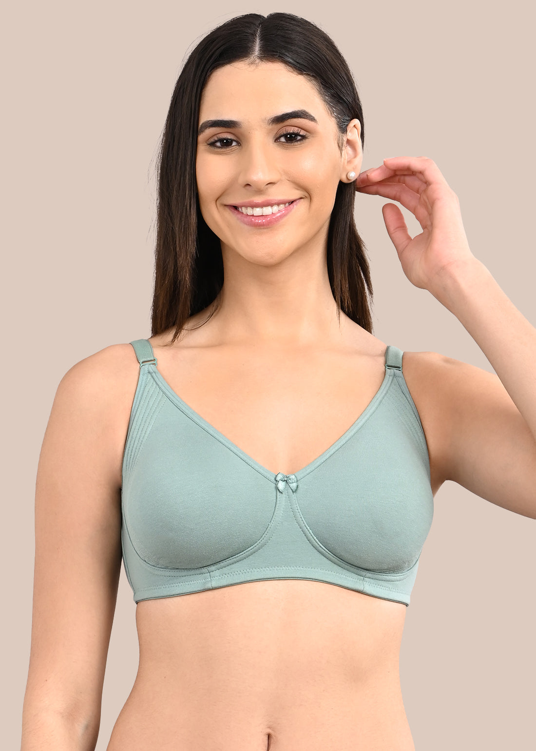 Woman wearing a bra against a neutral background