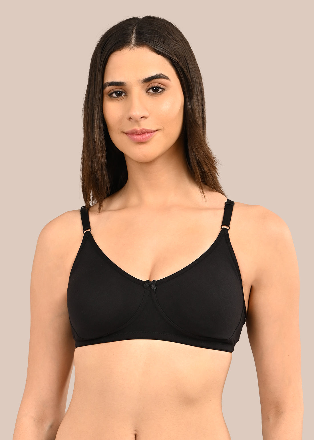 Woman wearing a bra against a neutral background