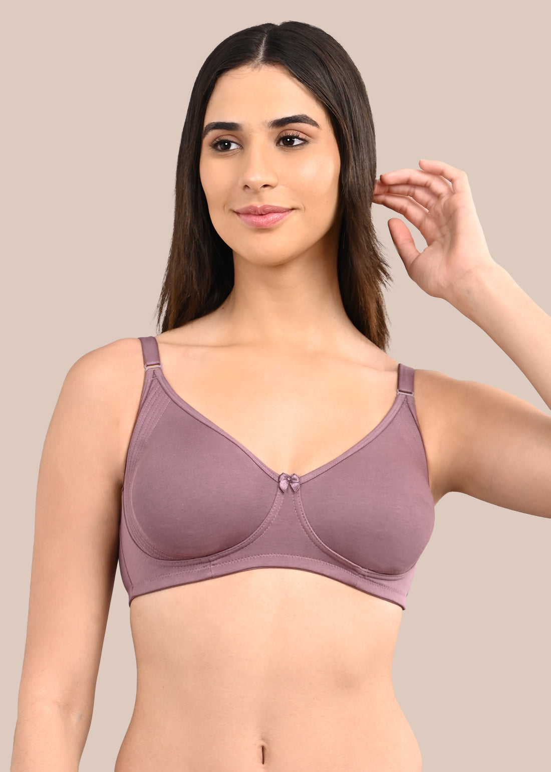 Woman wearing a bra against a neutral background