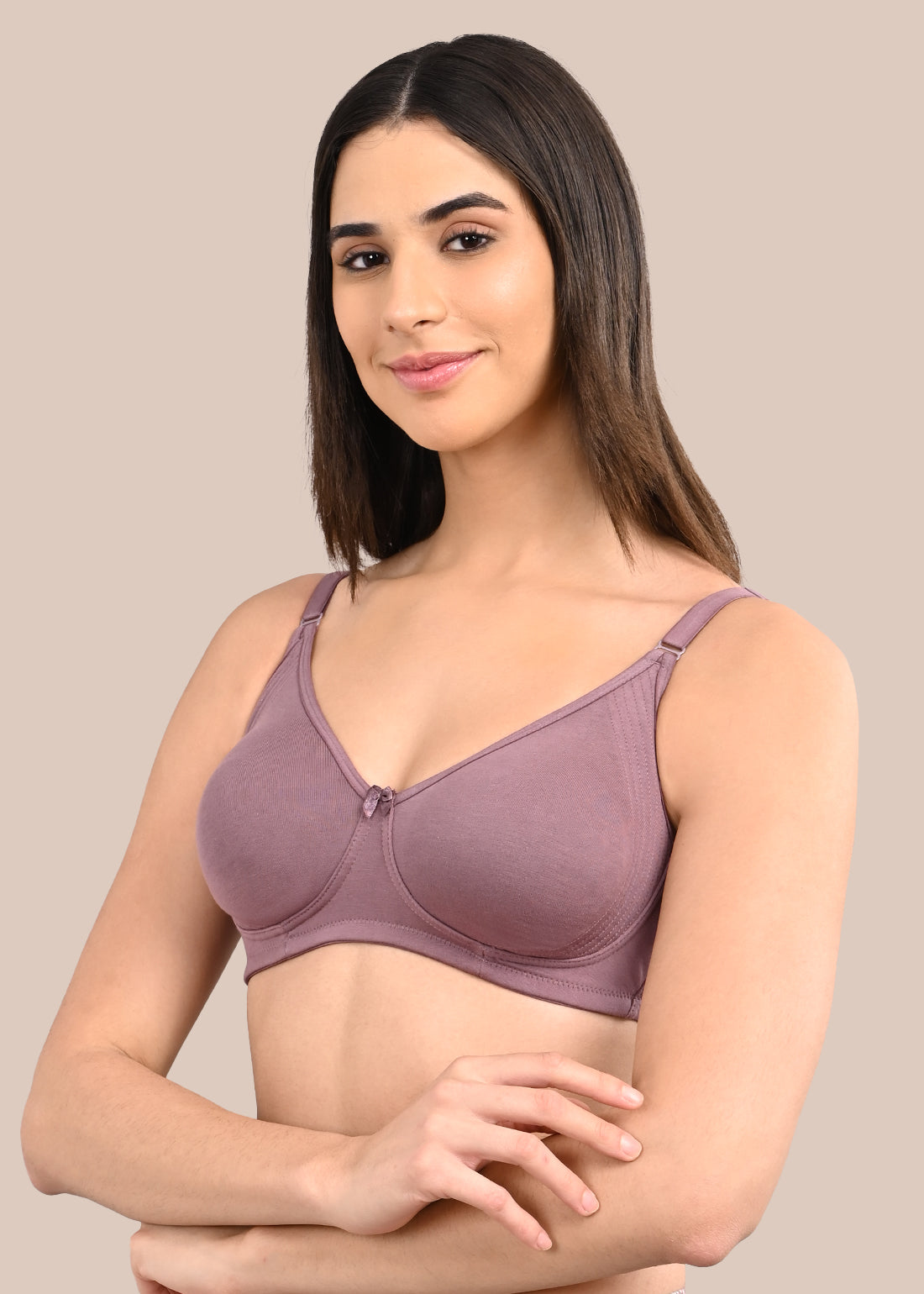 Woman wearing a bra against a neutral background