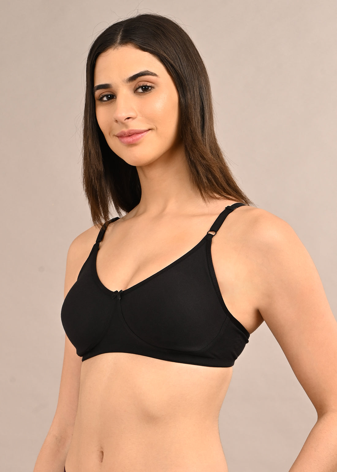 Woman wearing a bra against a neutral background