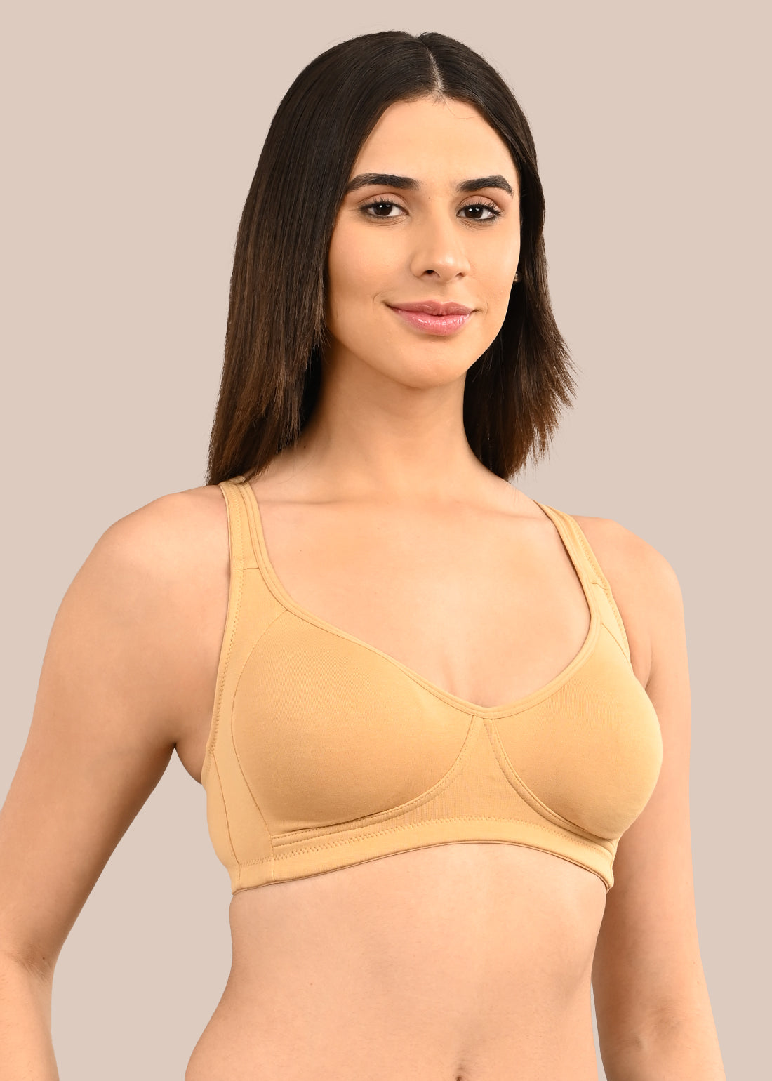 Woman wearing a bra against a neutral background