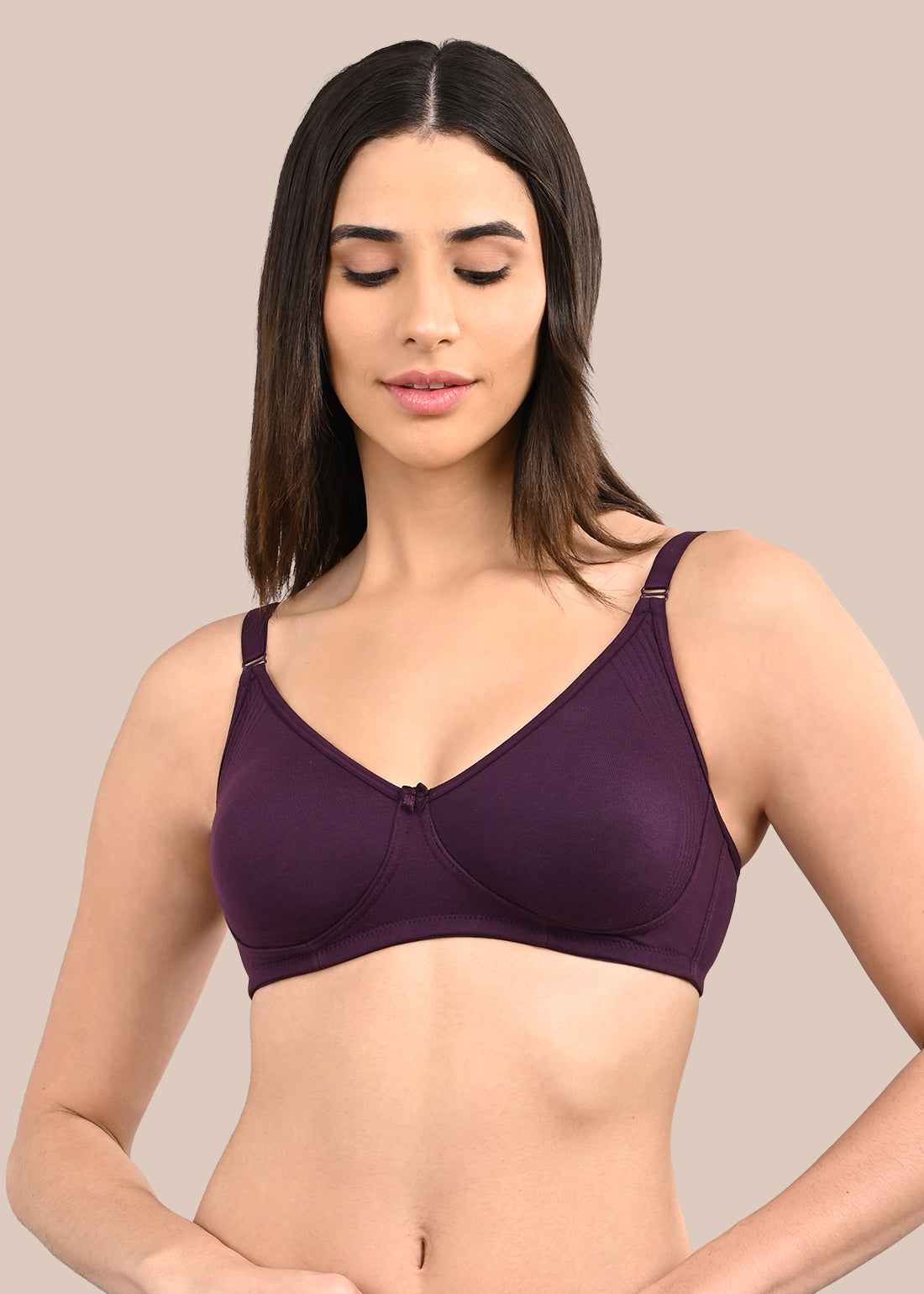 Woman wearing a bra against a neutral background