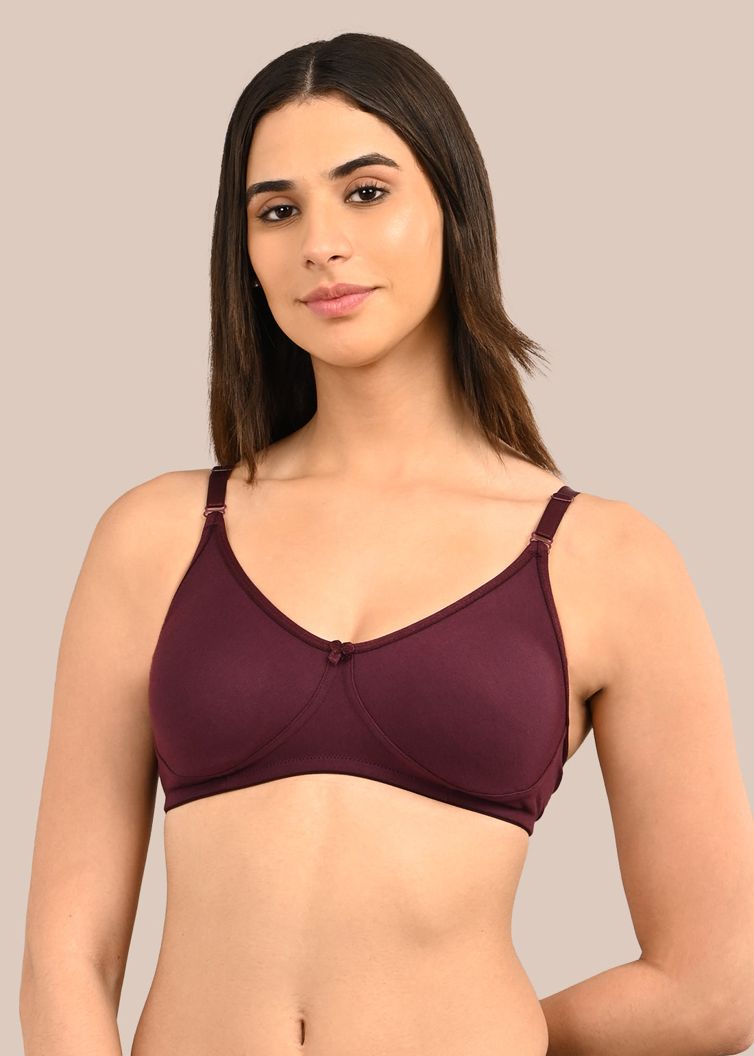 Woman wearing a bra against a neutral background