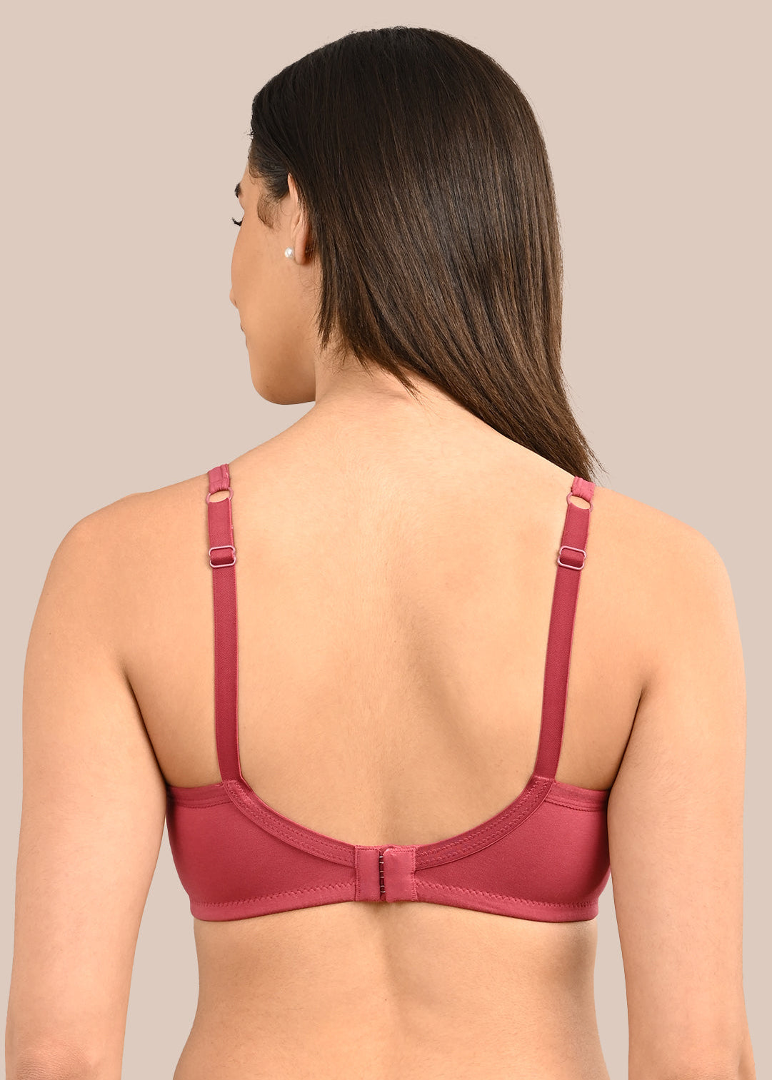 Woman wearing a bra against a neutral background