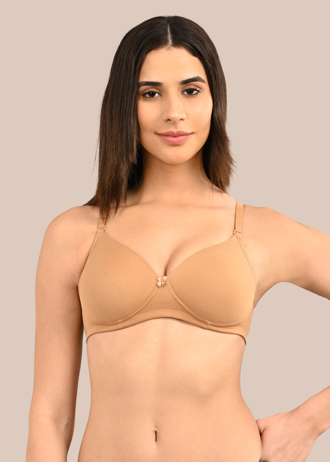 Woman wearing a bra against a neutral background