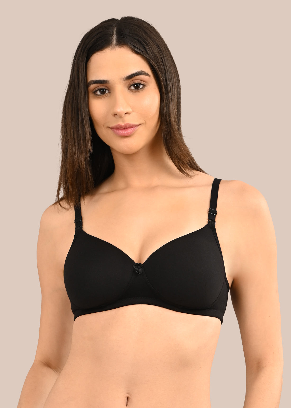 Woman wearing a bra against a neutral background