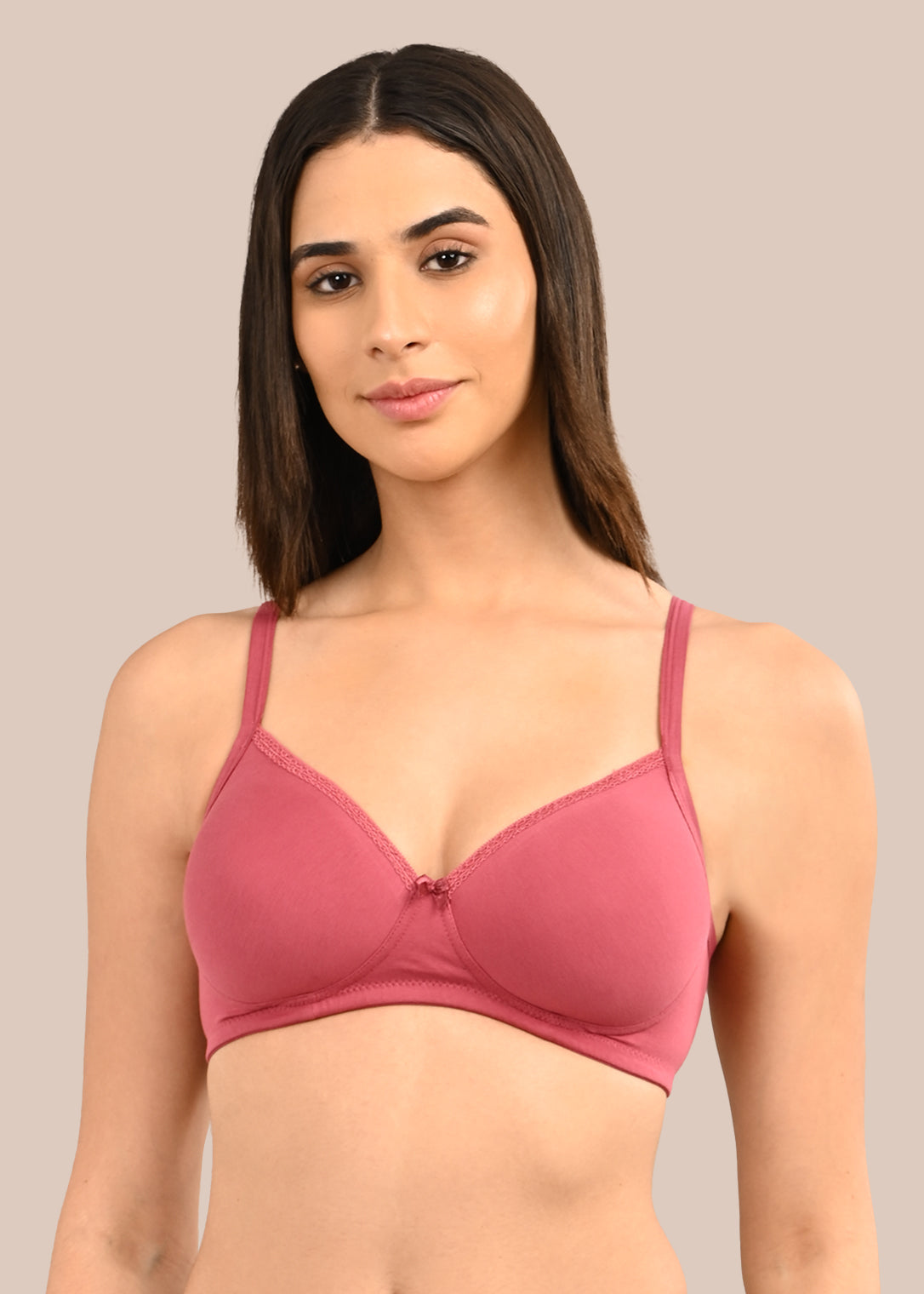 Woman wearing a bra against a neutral background