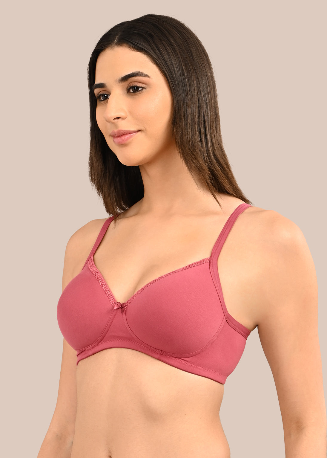 Woman wearing a bra against a neutral background