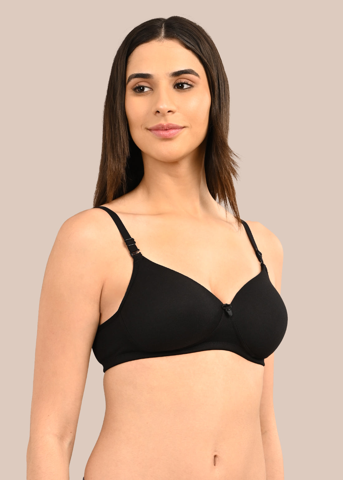 Woman wearing a bra against a neutral background