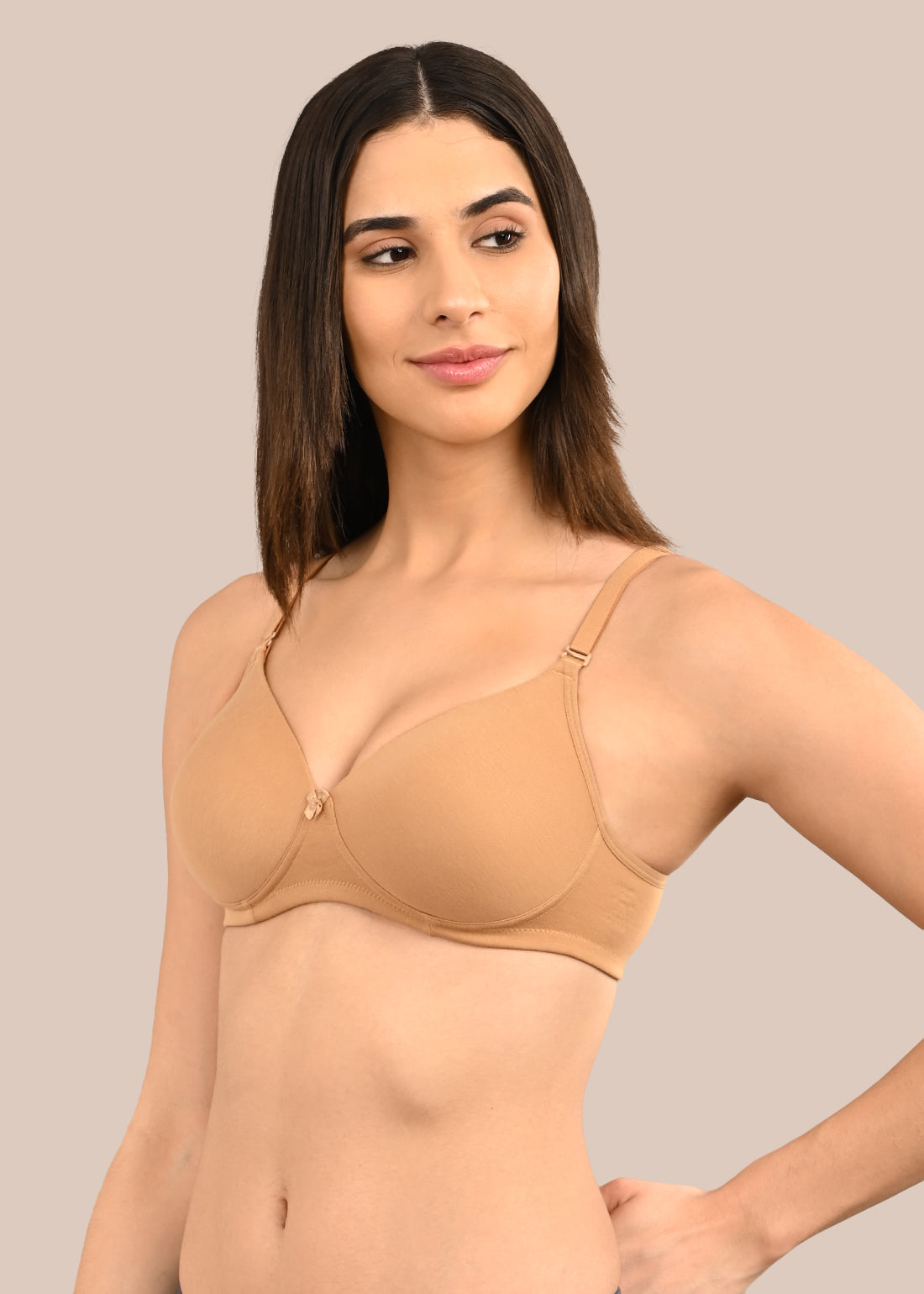 Woman wearing a bra against a neutral background