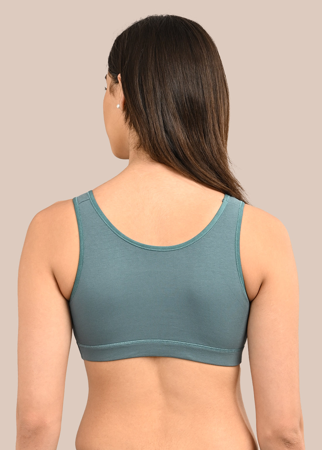 Woman wearing a bra against a neutral background
