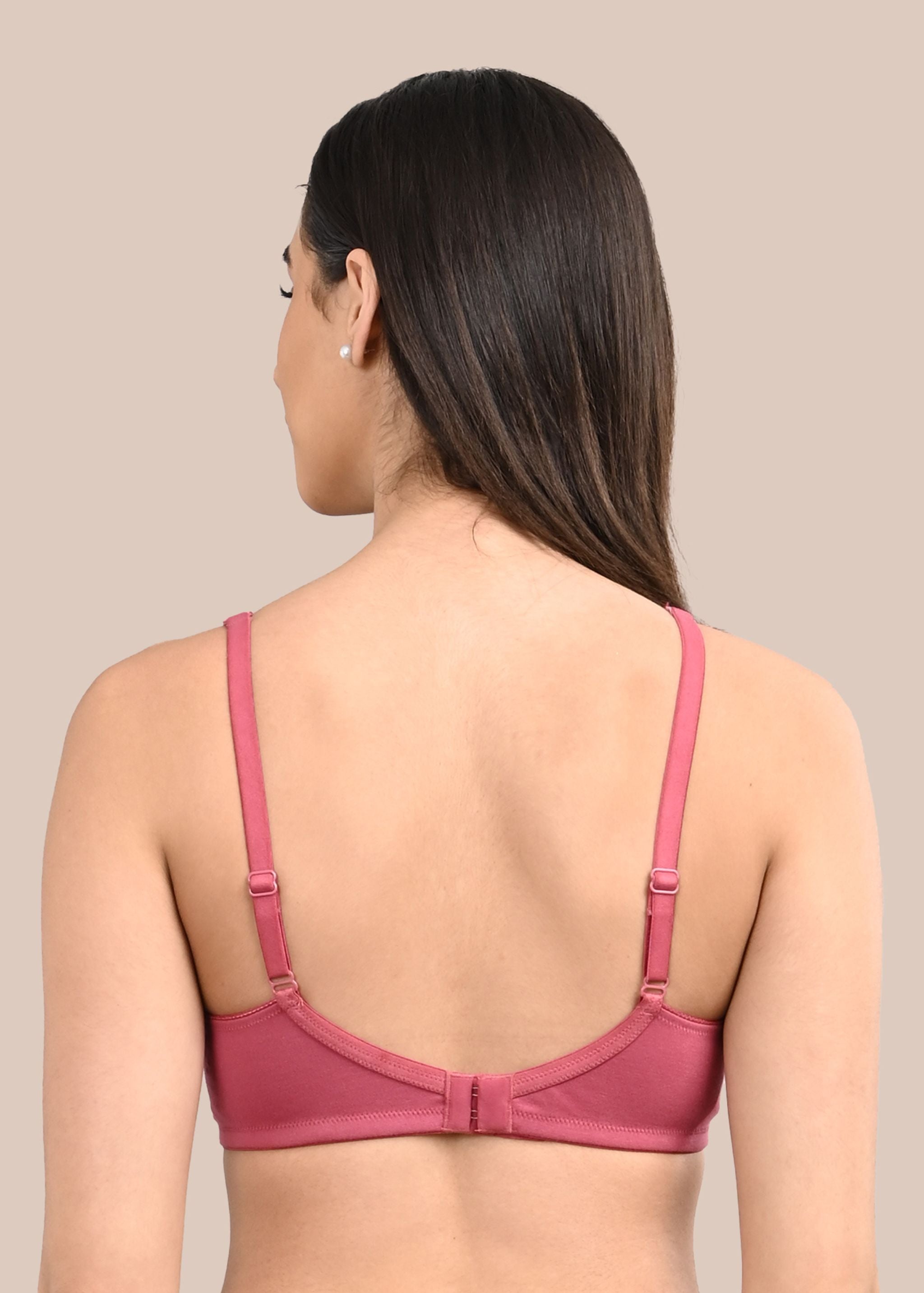 Woman wearing a bra against a neutral background