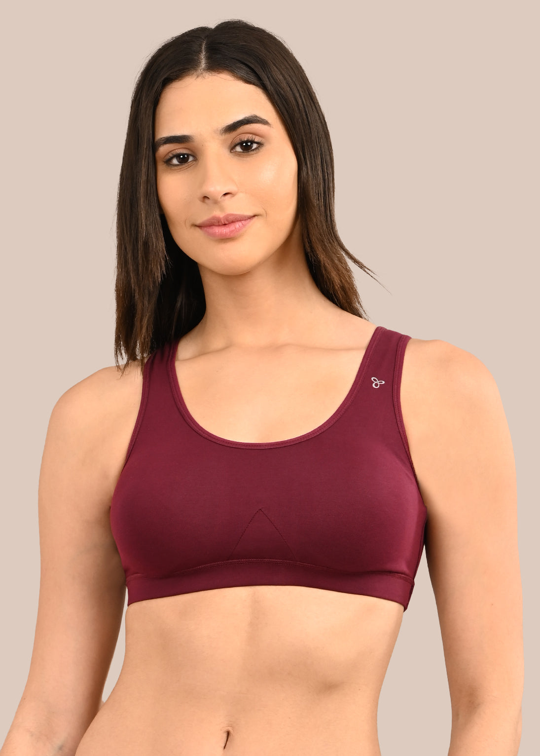 Woman wearing a bra against a neutral background