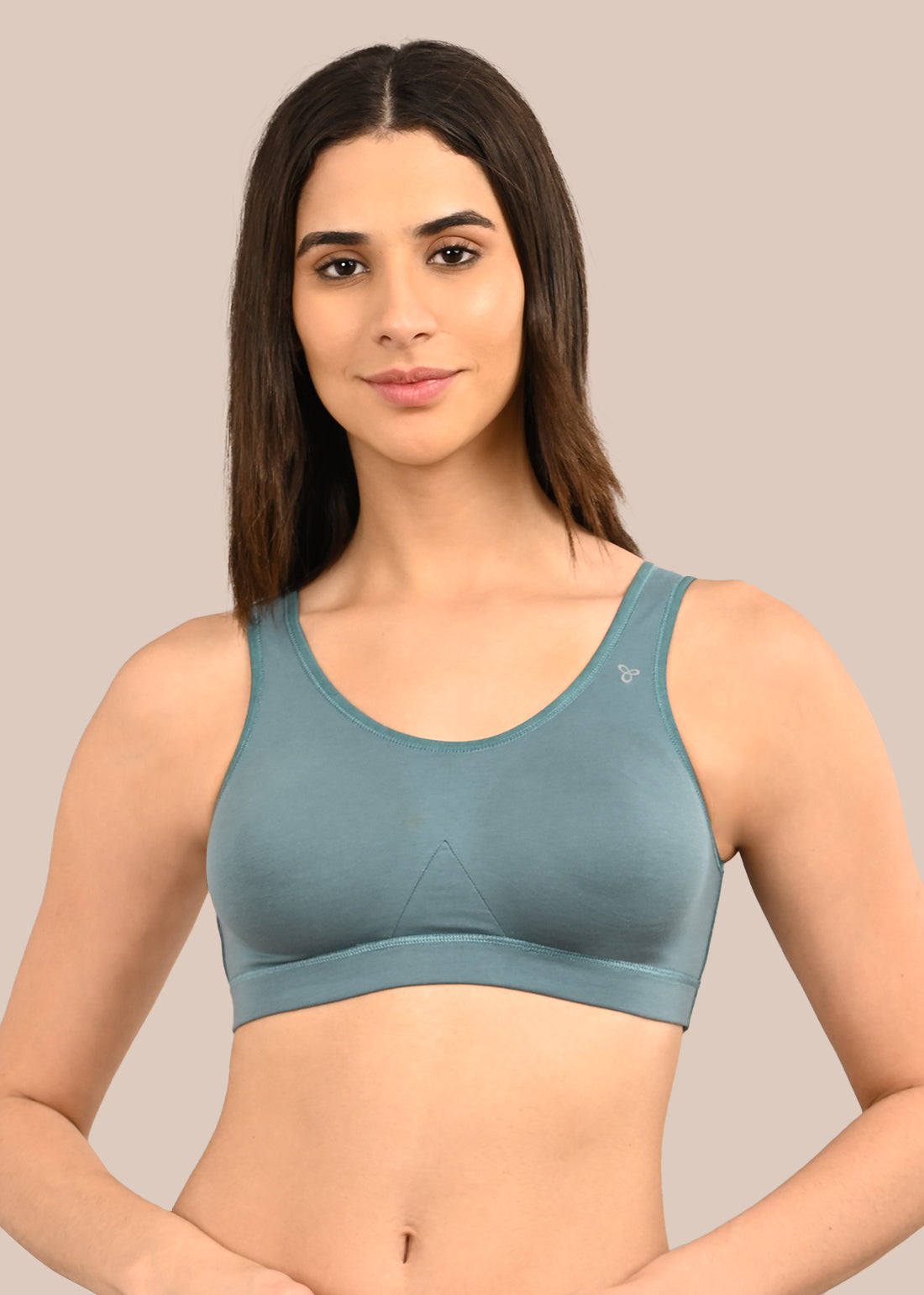 Woman wearing a bra against a neutral background