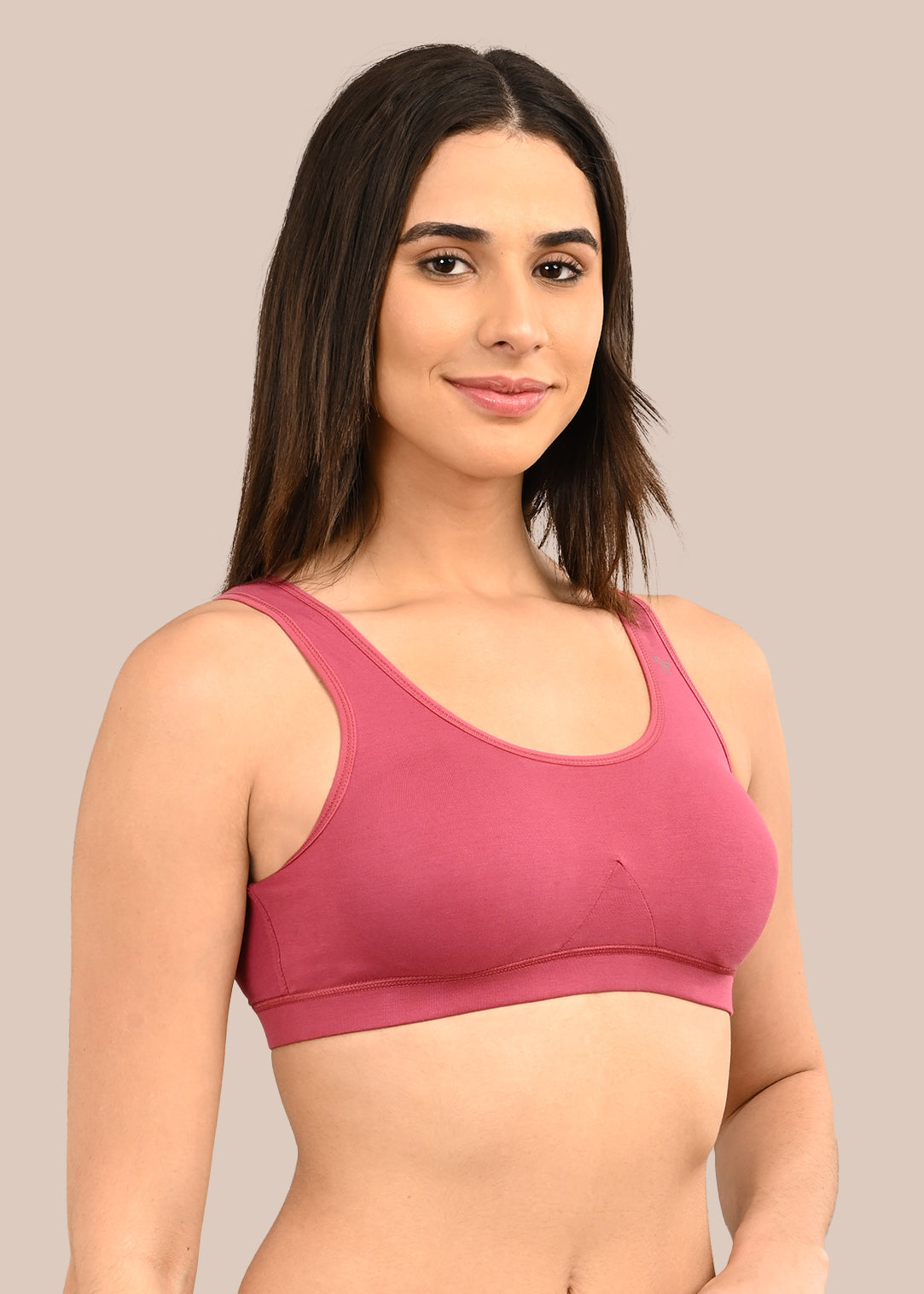 Woman wearing a bra against a neutral background