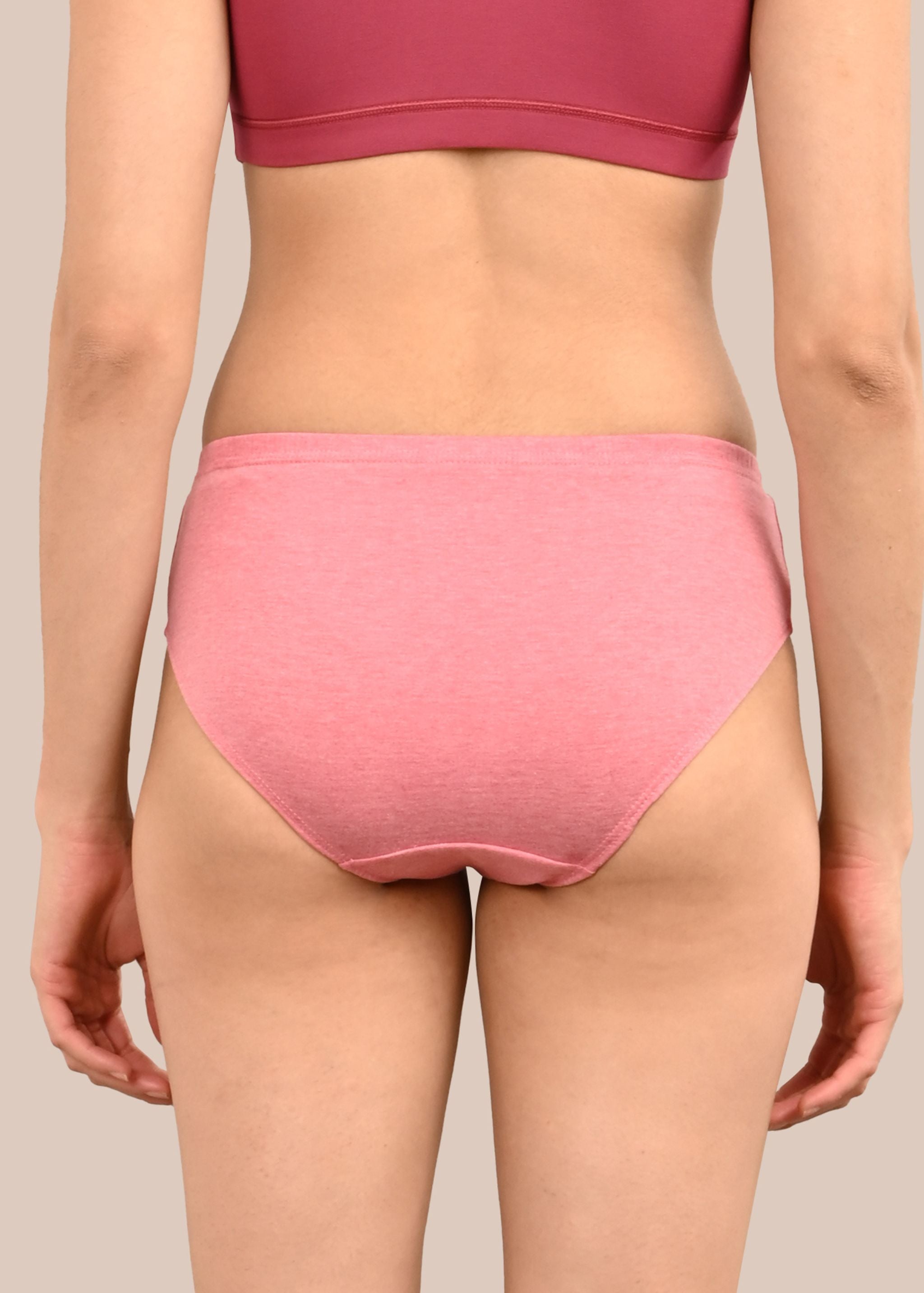 Woman wearing a bra against a neutral background