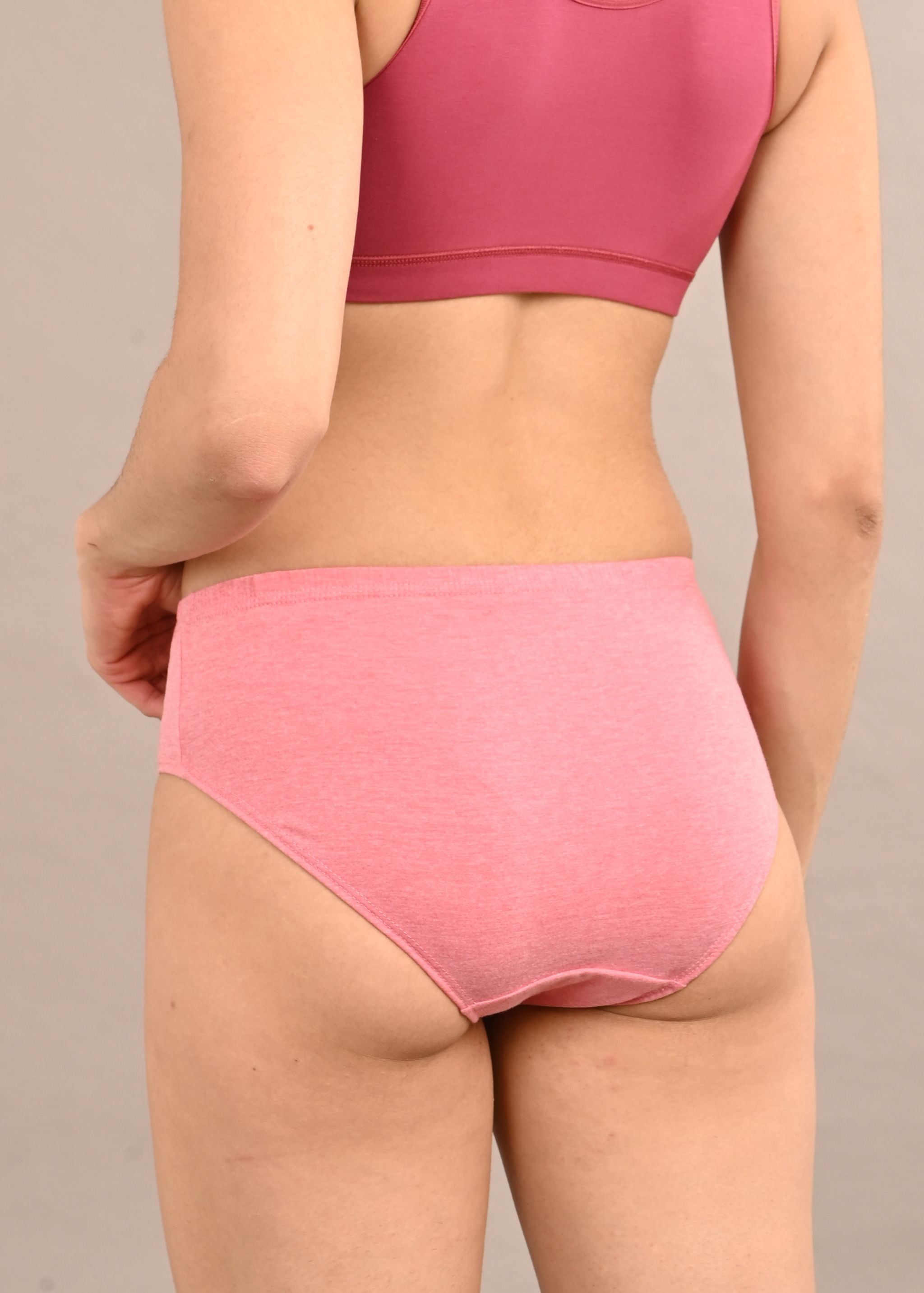 Woman wearing a bra against a neutral background