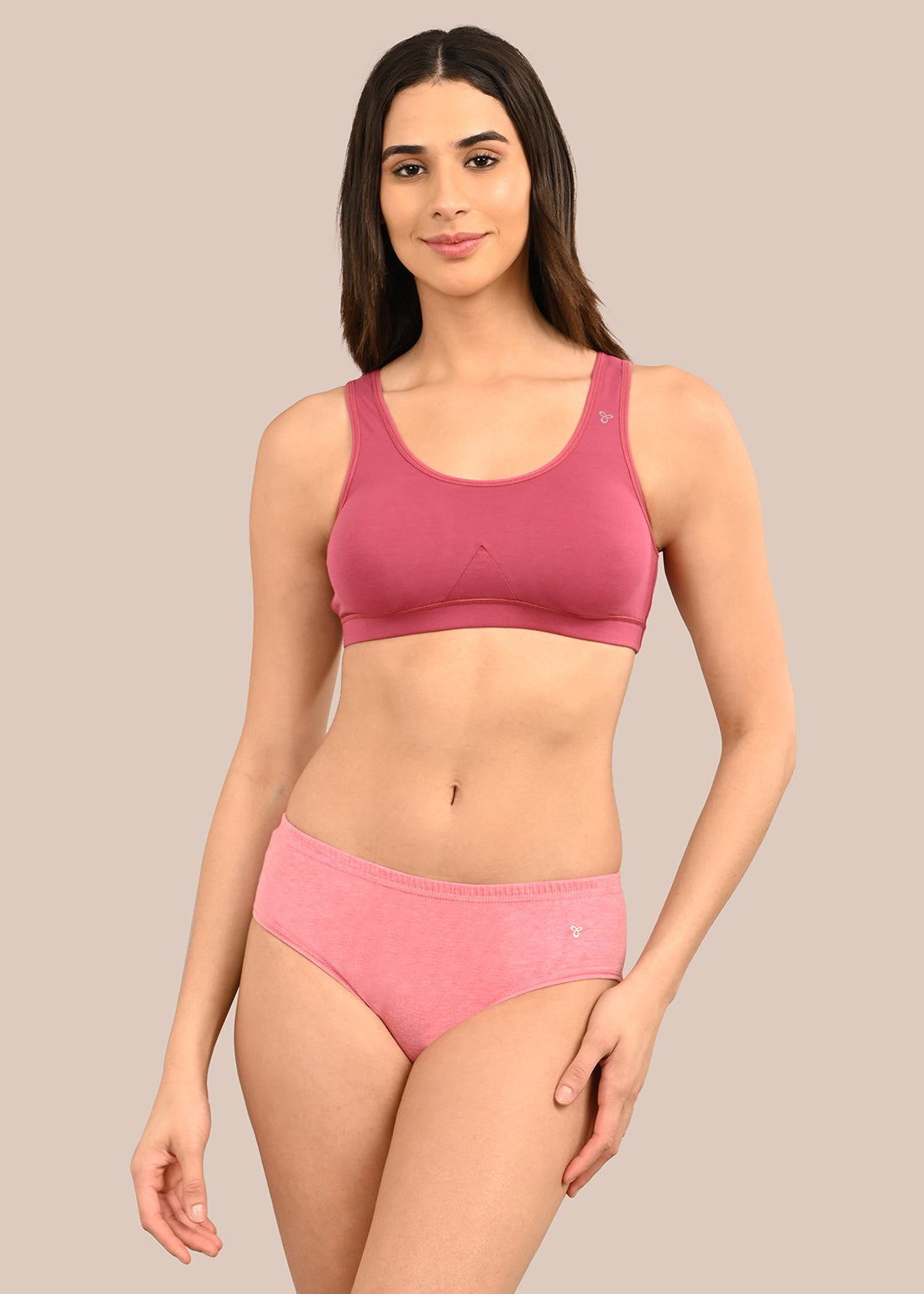Woman wearing a bra against a neutral background
