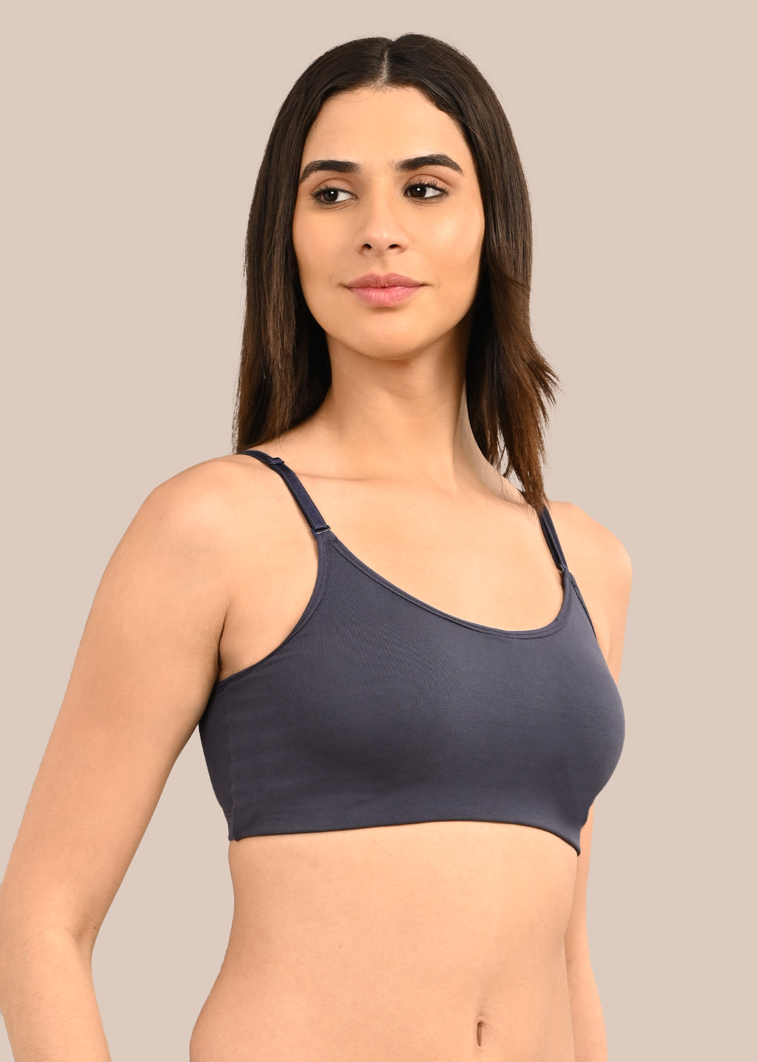 Woman wearing a bra against a neutral background