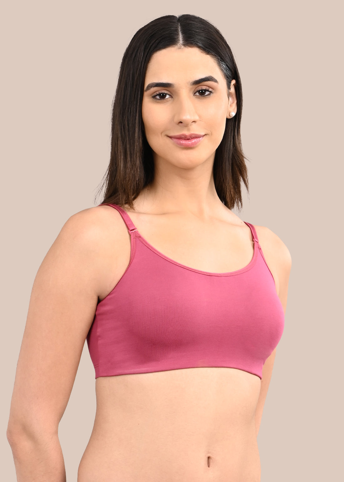 Woman wearing a bra against a neutral background