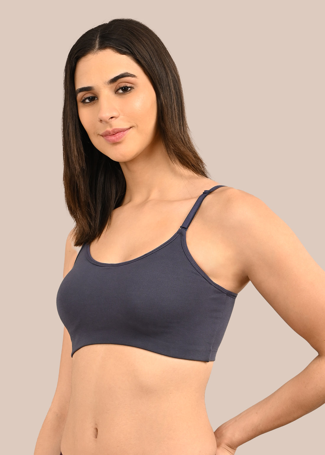 Woman wearing a bra against a neutral background