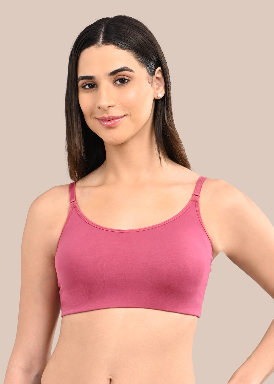 Woman wearing a bra against a neutral background