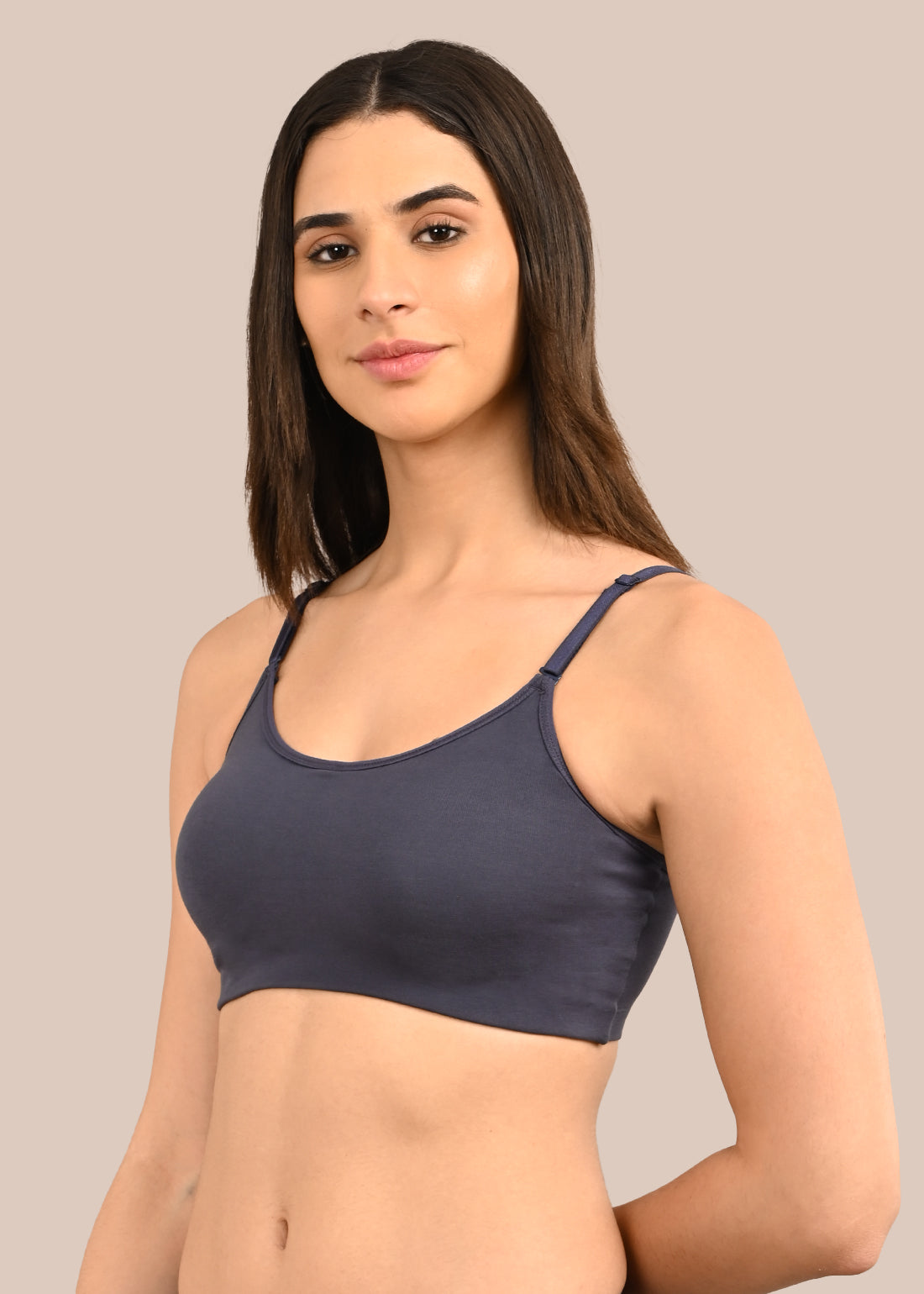 Woman wearing a bra against a neutral background