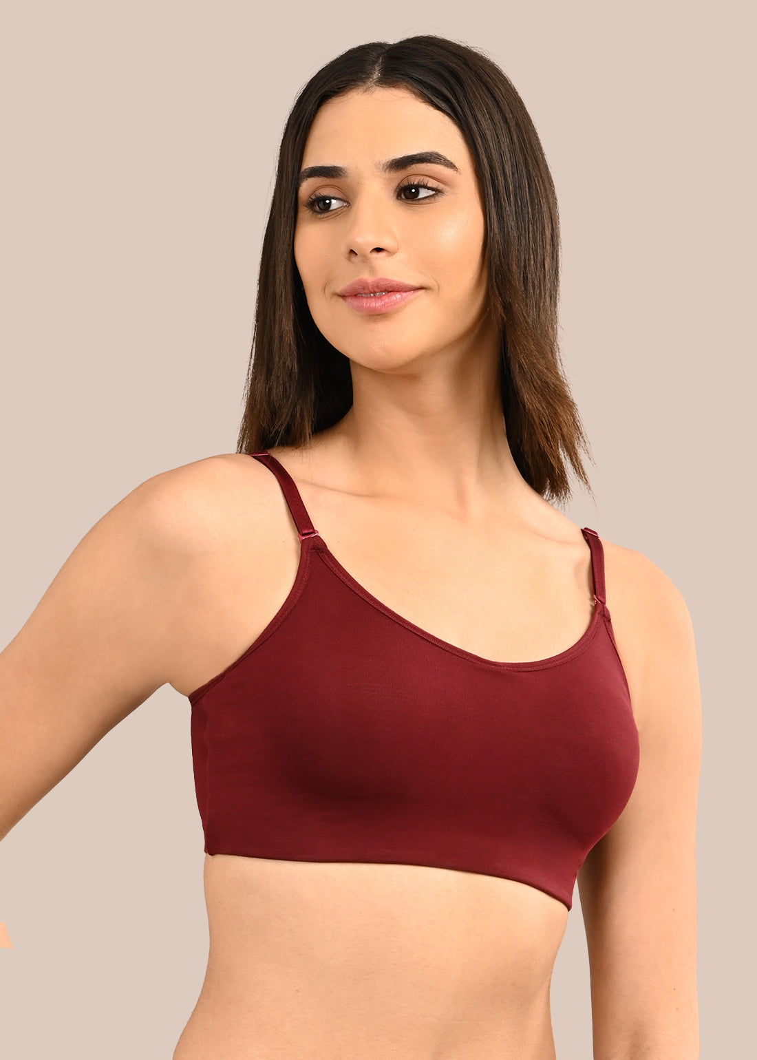 Woman wearing a bra against a neutral background