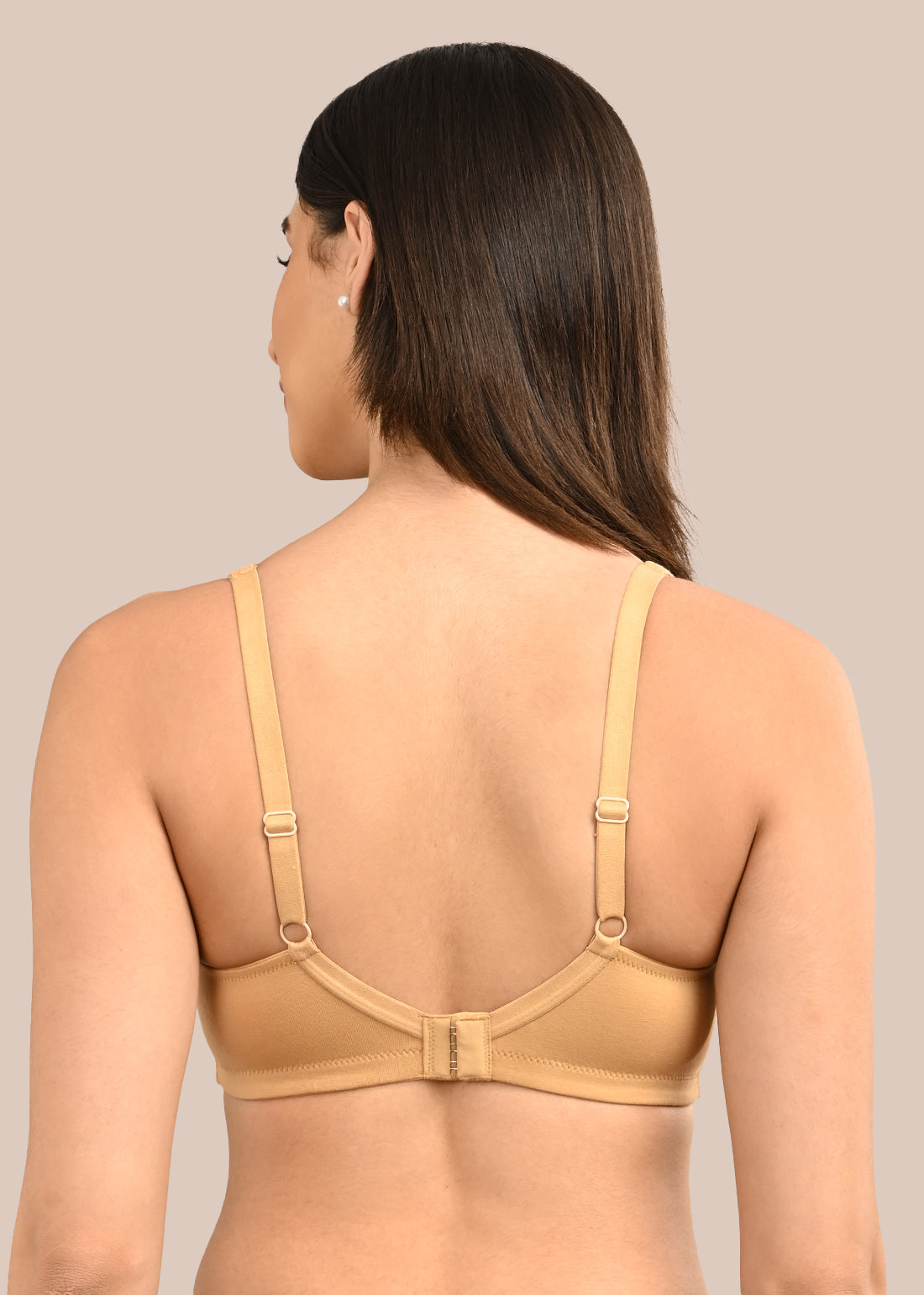 Woman wearing a bra against a neutral background