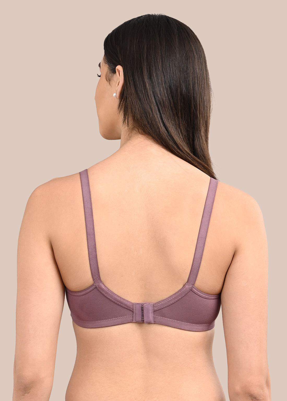 Woman wearing a bra against a neutral background
