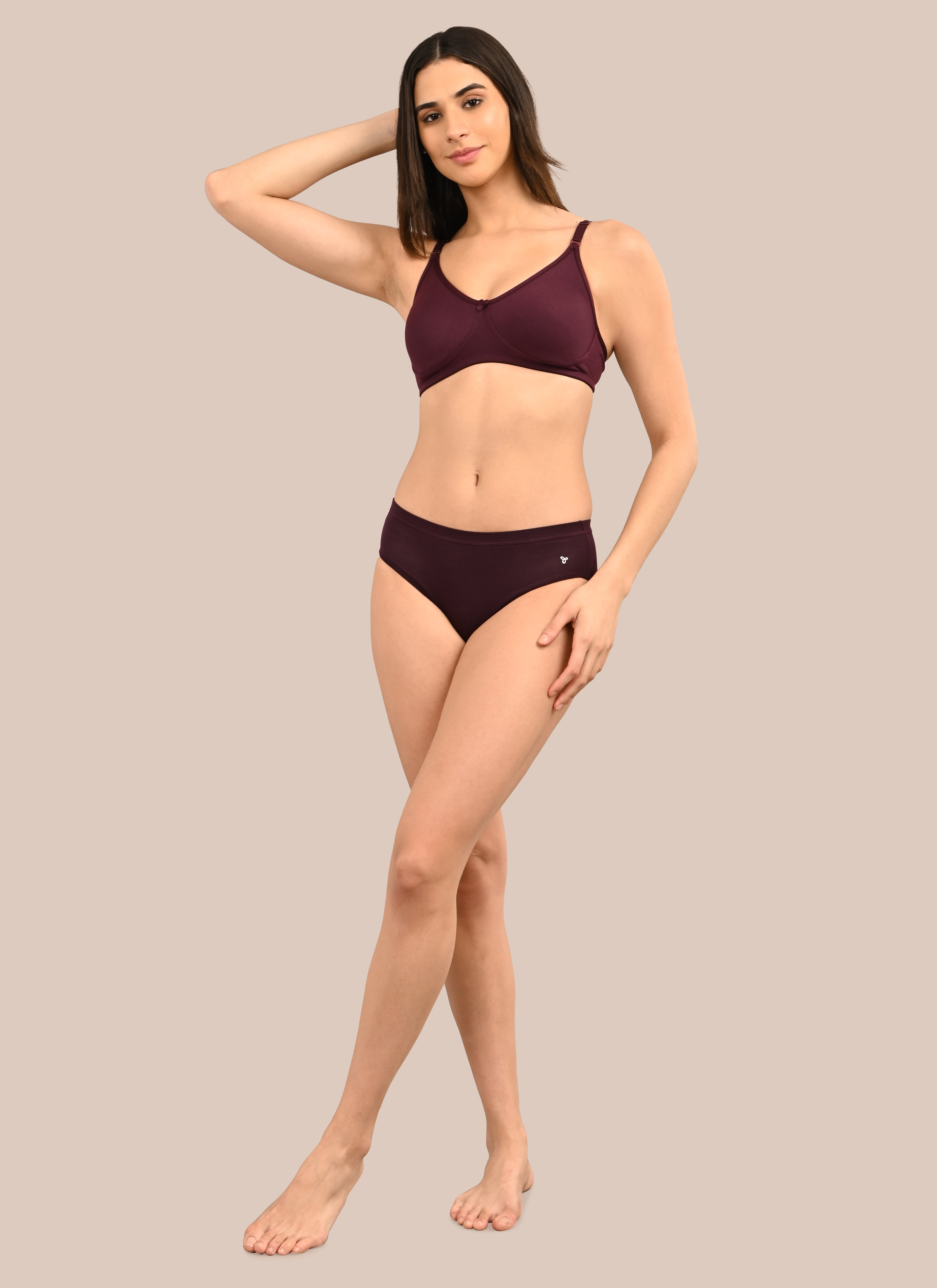 Woman wearing a bra against a neutral background