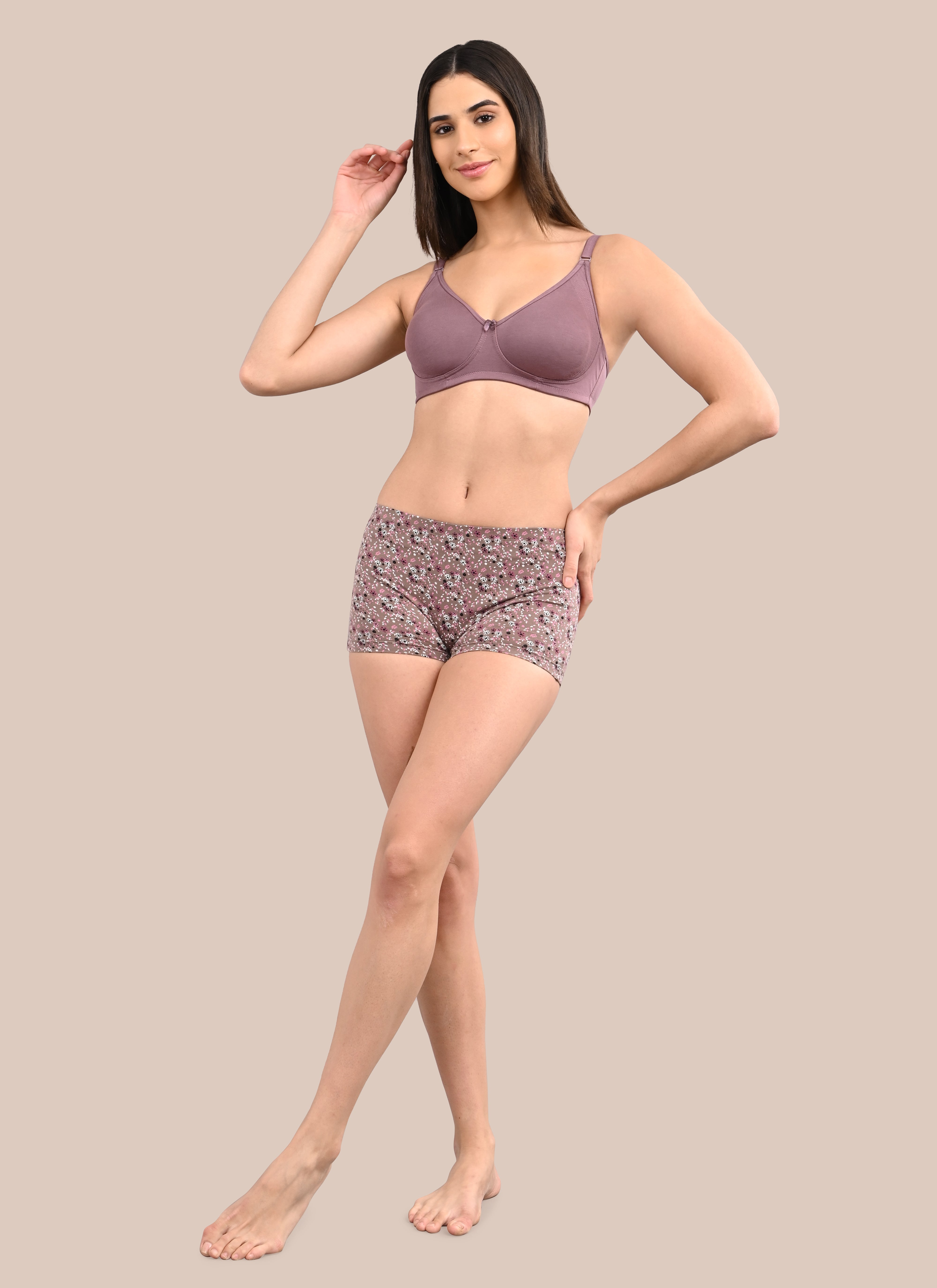Woman wearing a bra against a neutral background