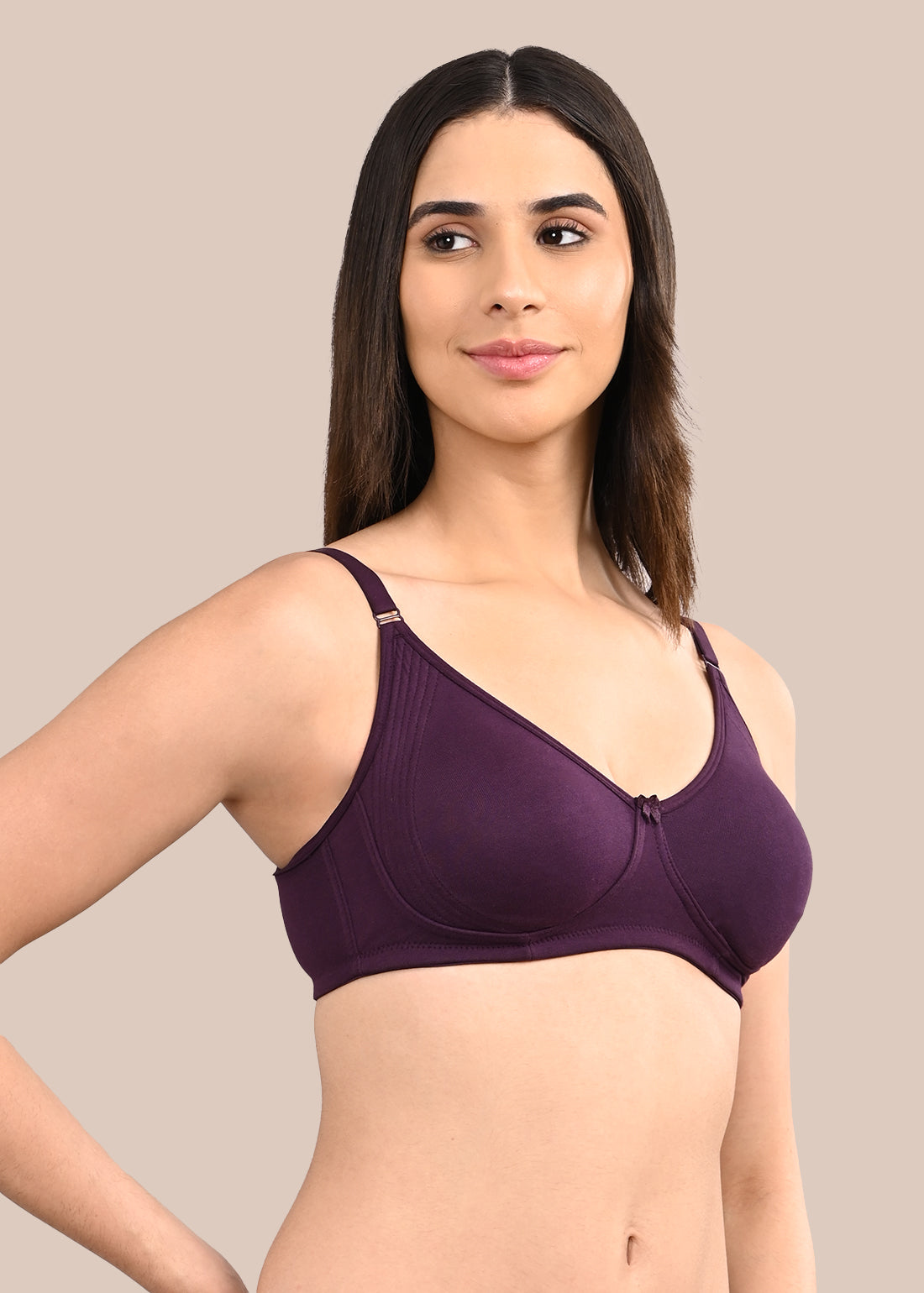 Woman wearing a bra against a neutral background
