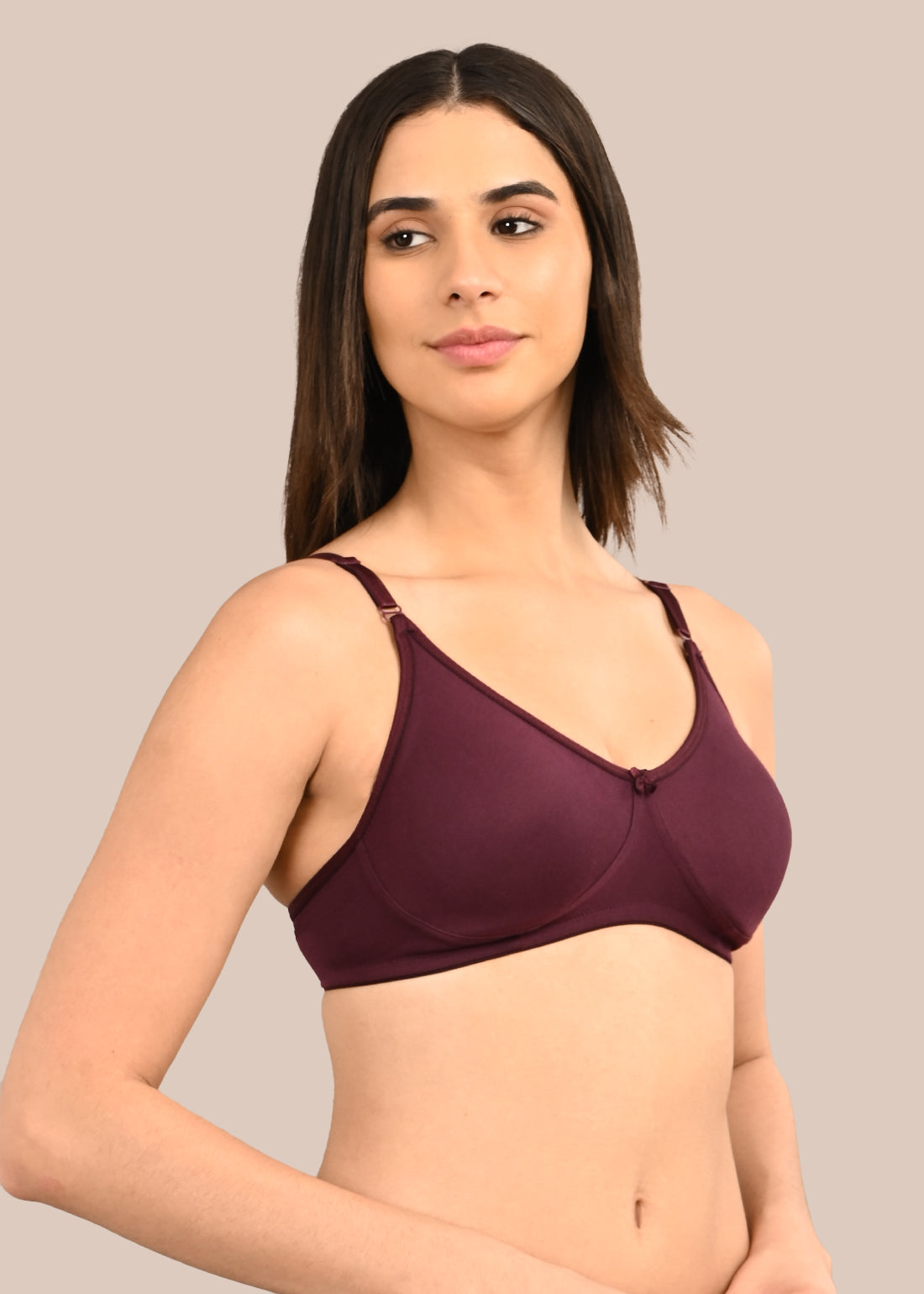 Woman wearing a bra against a neutral background
