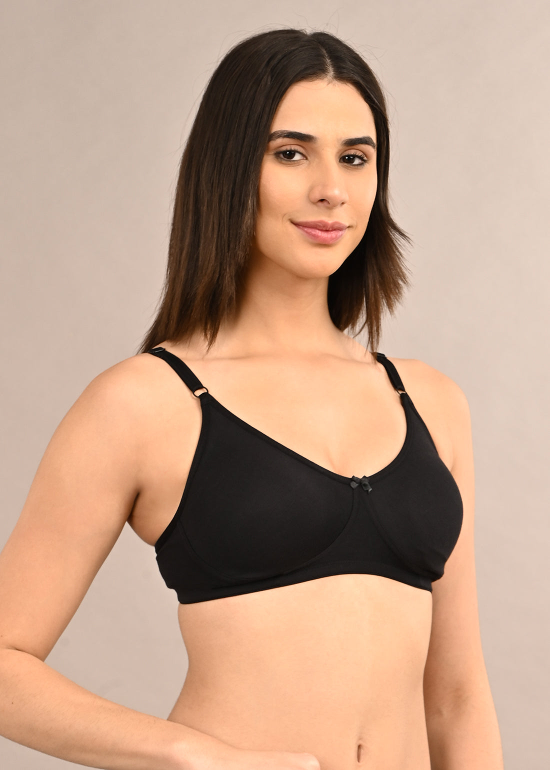 Woman wearing a bra against a neutral background