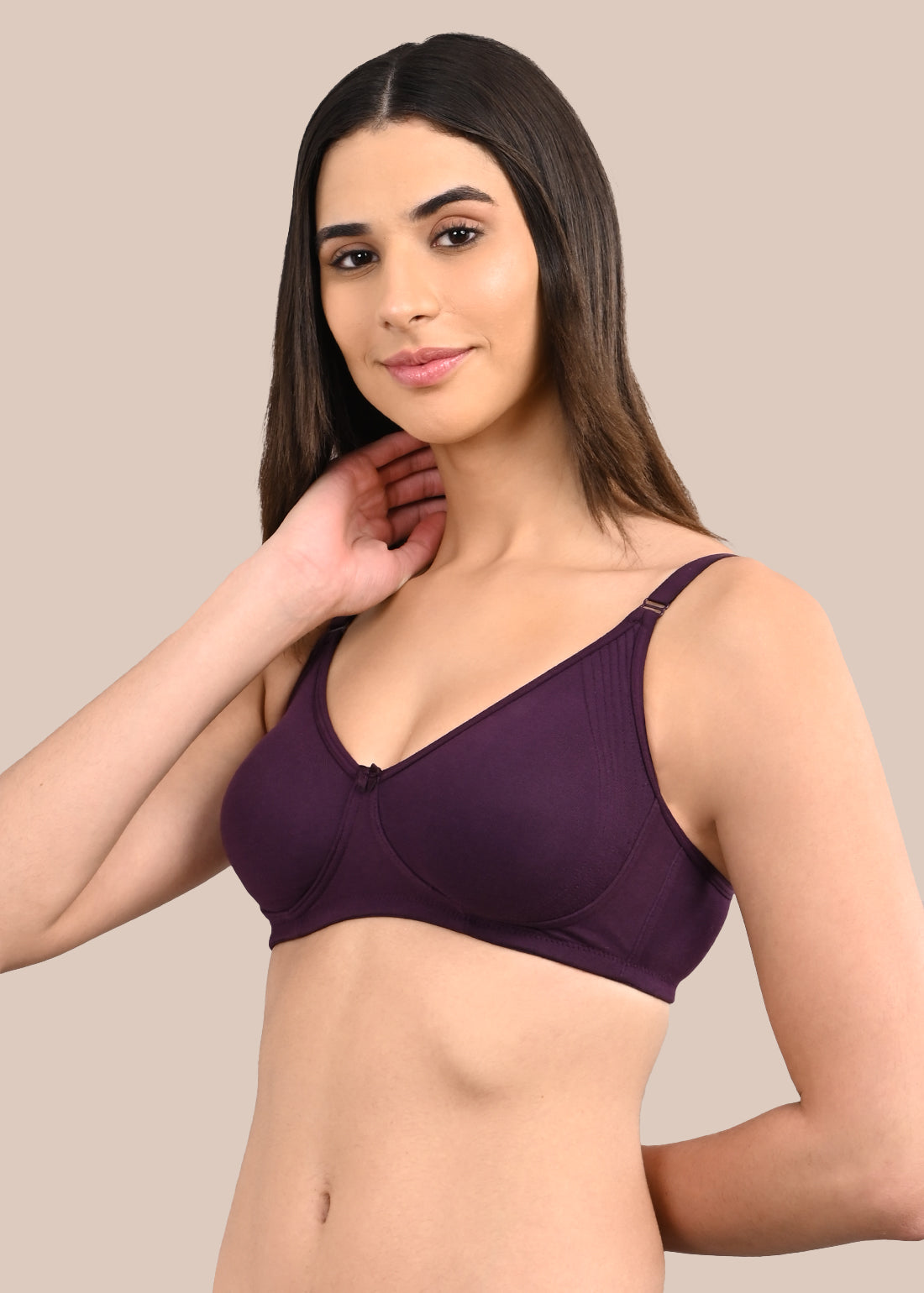 Woman wearing a bra against a neutral background
