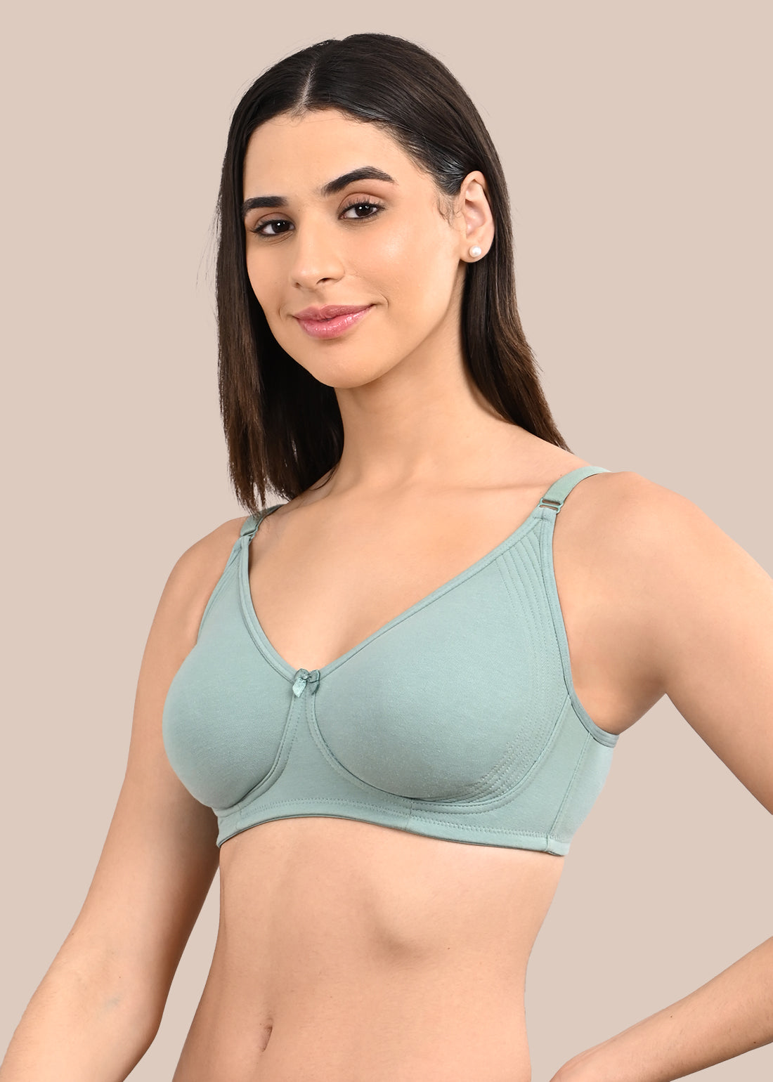 Woman wearing a bra against a neutral background