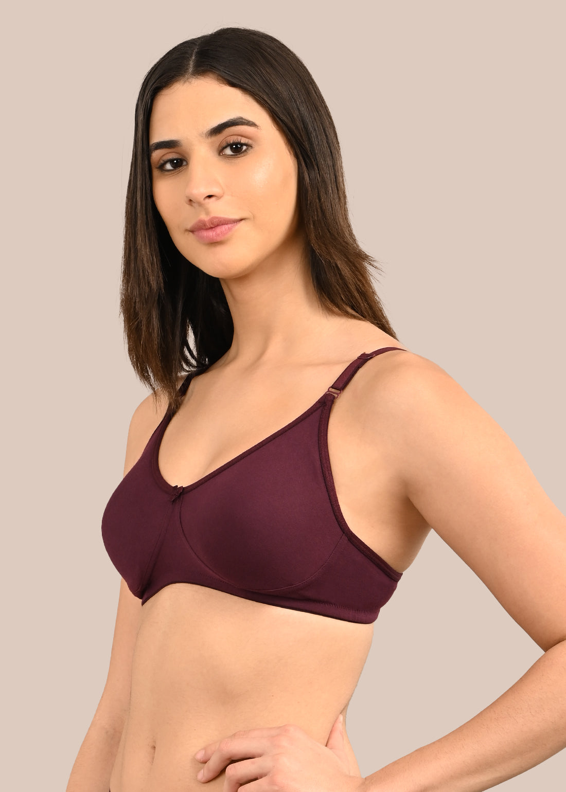 Woman wearing a bra against a neutral background